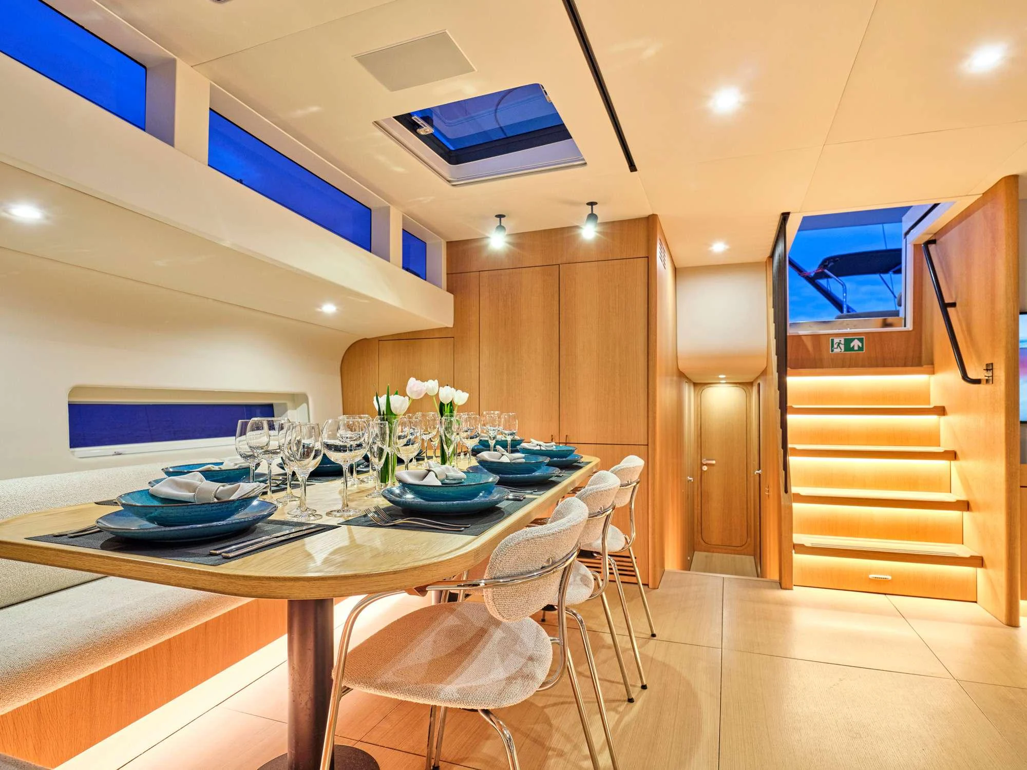a dining table with plates and glasses aboard NADAMAS Yacht for Charter