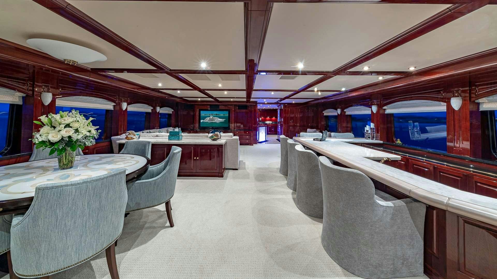 a room with a table chairs and a television aboard LADY ELAINE Yacht for Charter