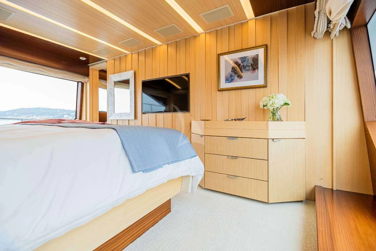 a room with a bed and a television aboard LULU Yacht for Charter