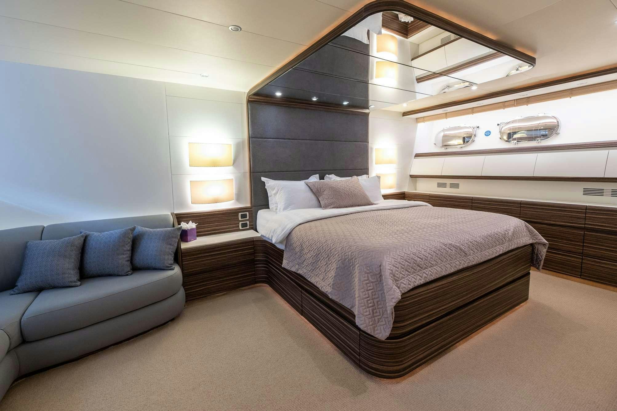 a bedroom with a bed and a couch aboard PEREAKI II Yacht for Charter