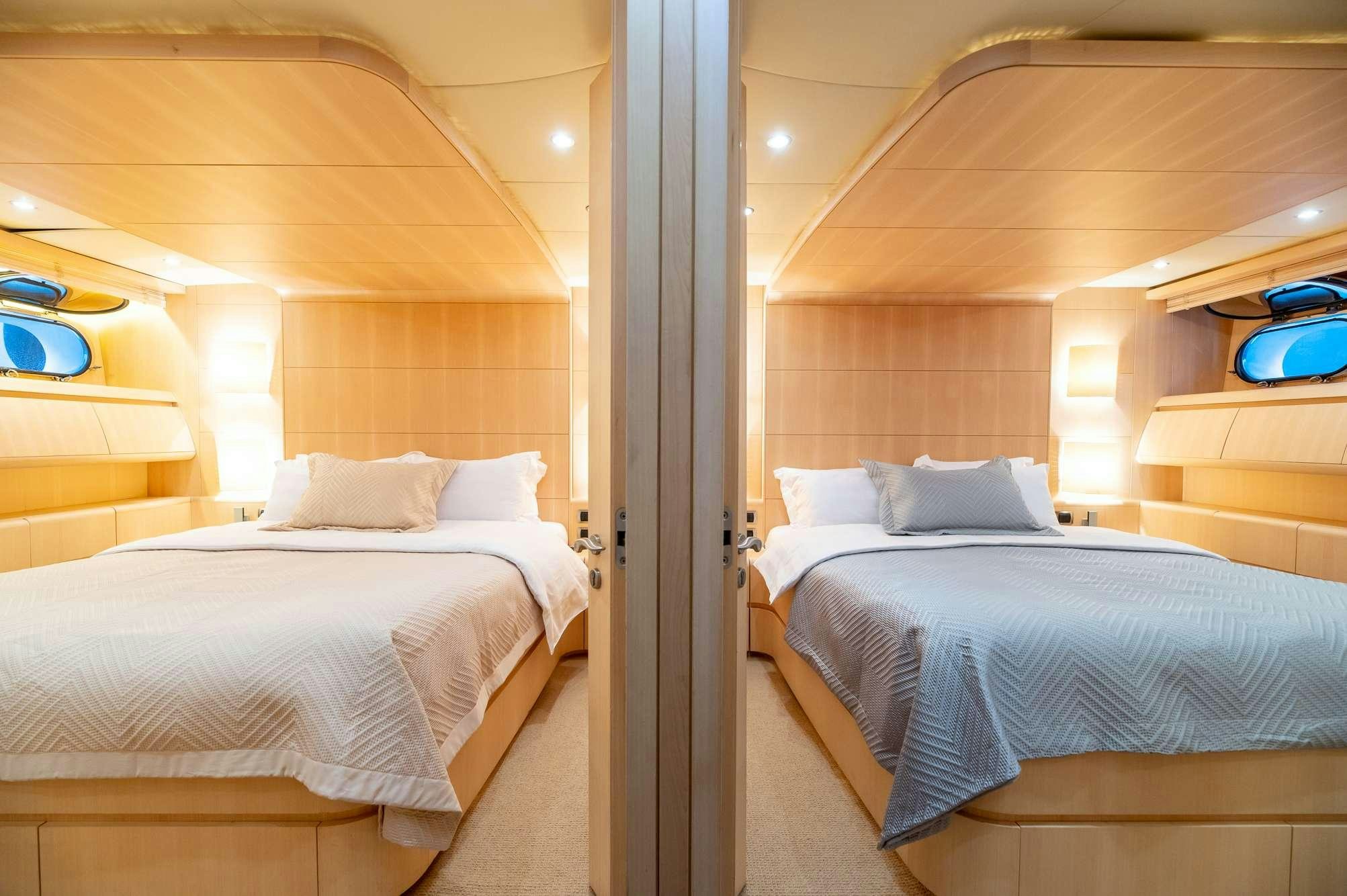 a room with beds and a mirror aboard PEREAKI II Yacht for Charter