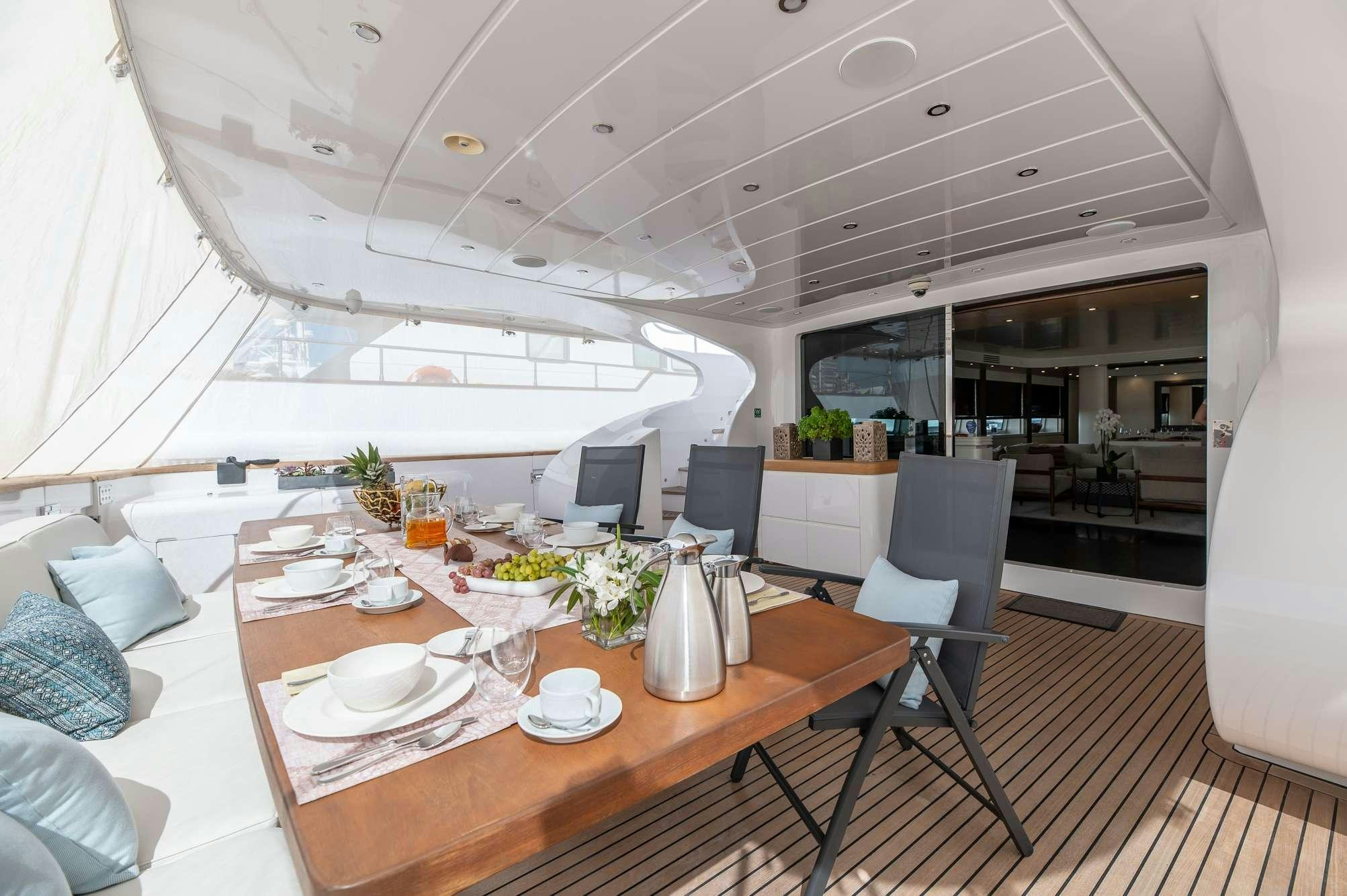 a large white room with a table and chairs aboard PEREAKI II Yacht for Charter
