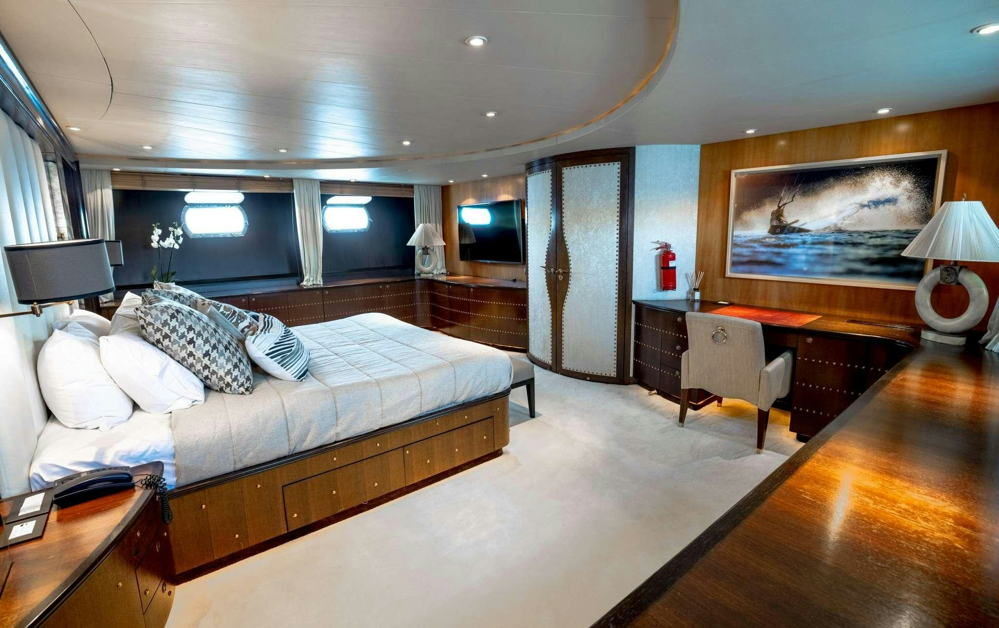 a hotel room with a bed and desk aboard MOBIUS Yacht for Charter