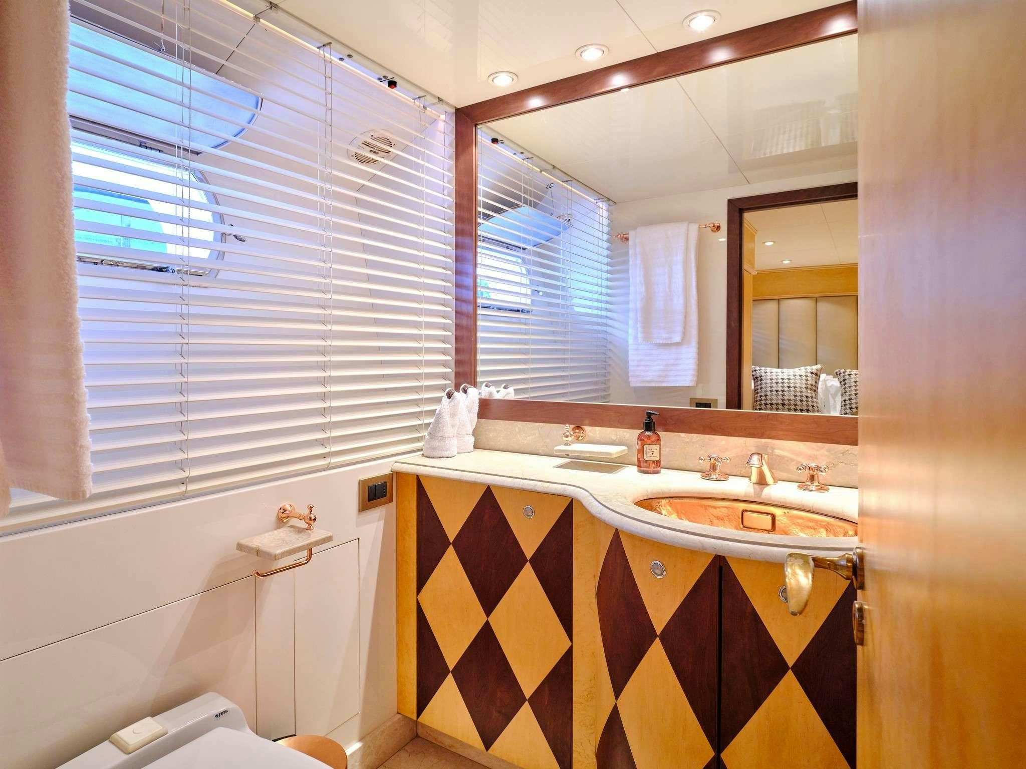 a bathroom with a tub sink and a mirror aboard MOBIUS Yacht for Charter
