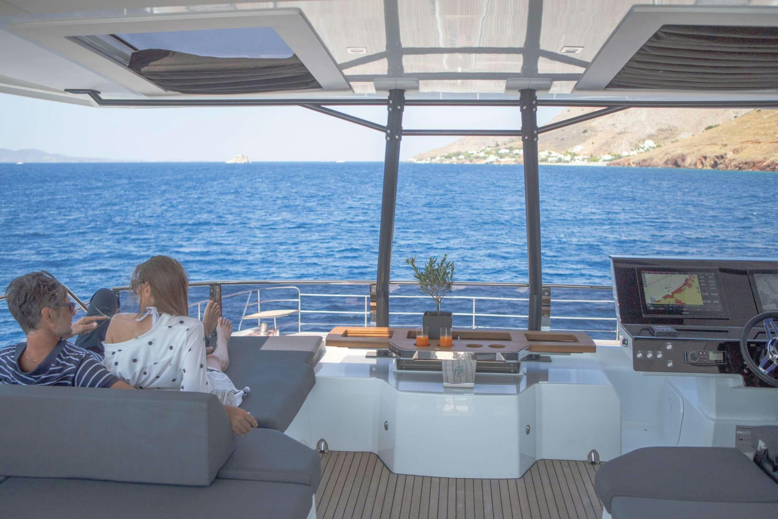 a couple of people sitting on a couch on a boat aboard ELLY Yacht for Charter