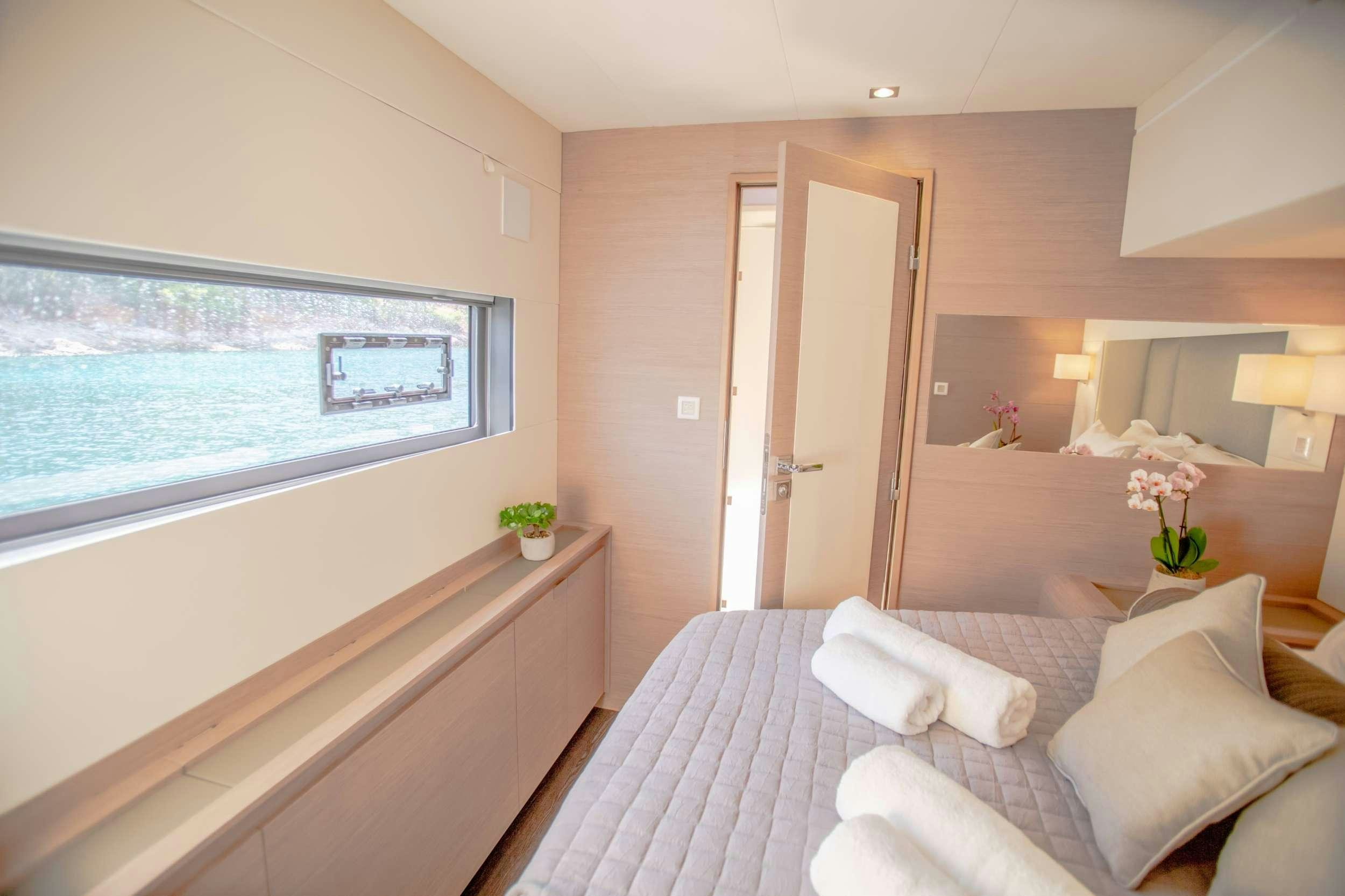 a room with a bed and a window aboard ELLY Yacht for Charter