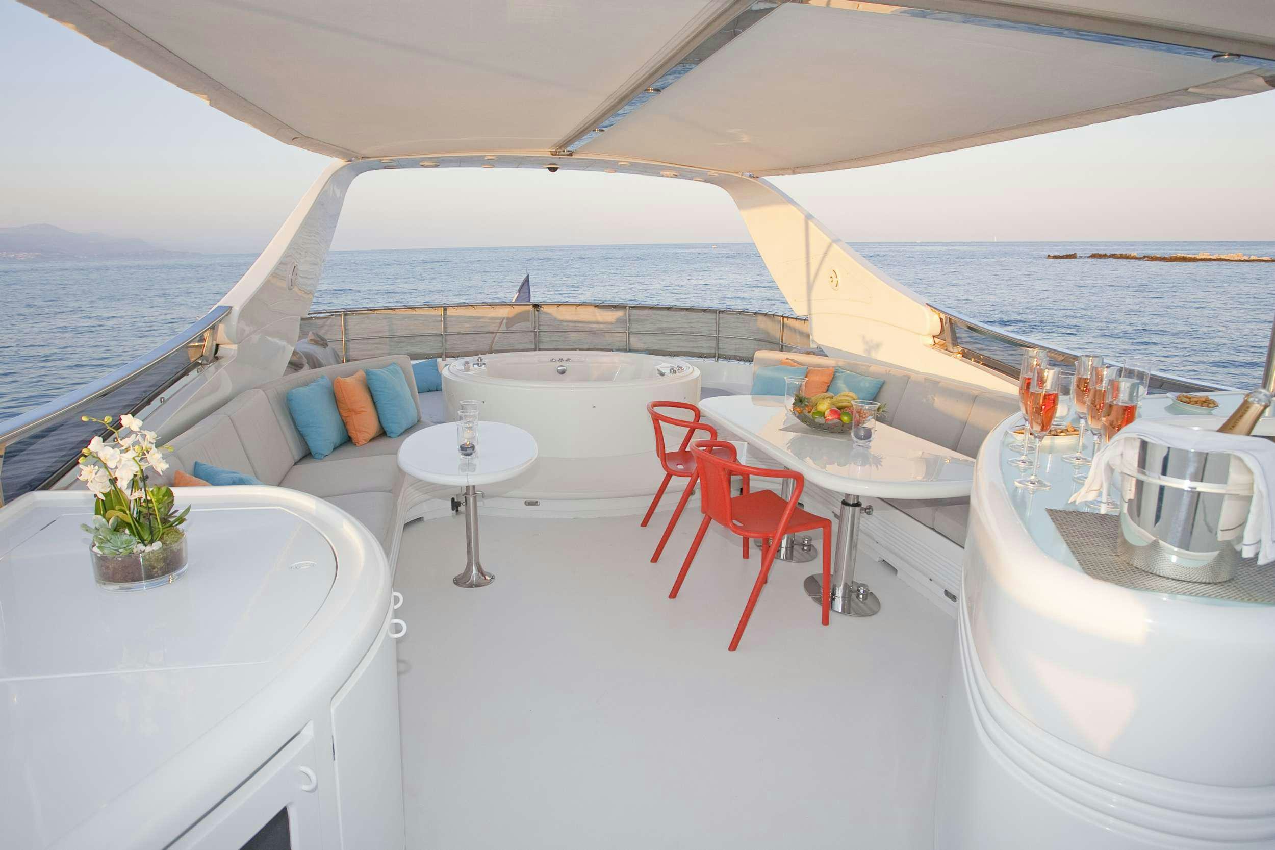 a table with chairs on it next to a large body of water aboard COCA VI Yacht for Charter