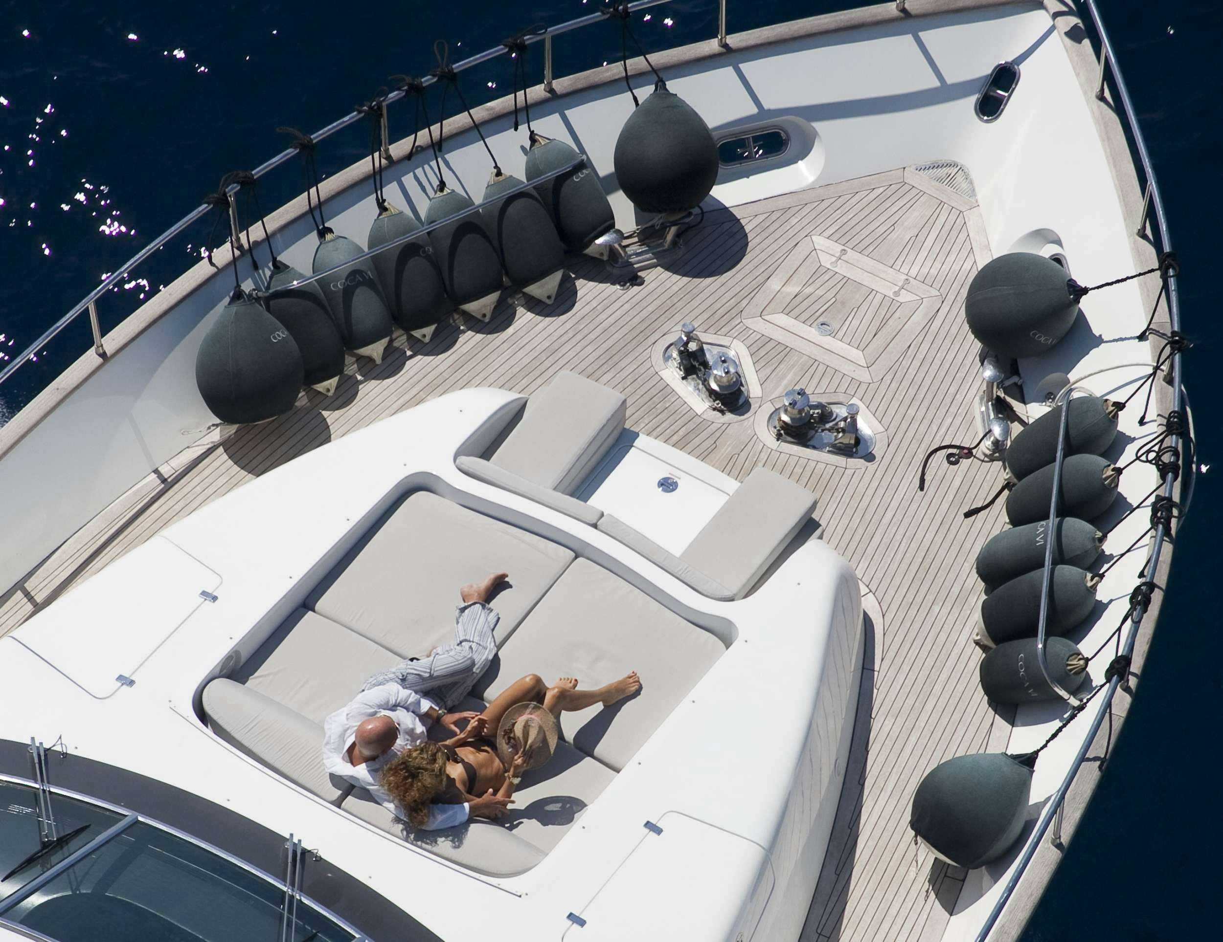 a group of people on a stage aboard COCA VI Yacht for Charter