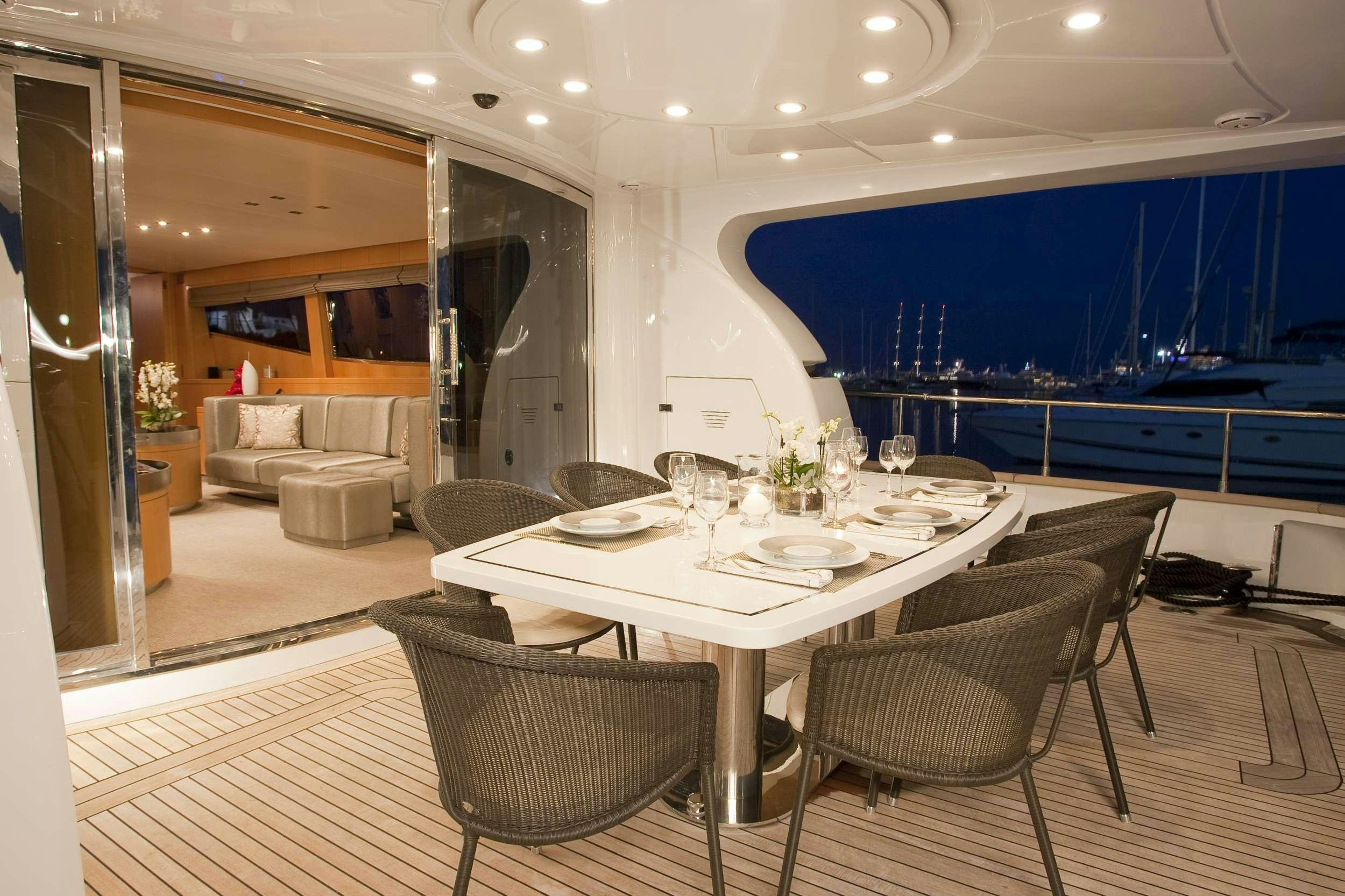 a large room with a table and chairs aboard COCA VI Yacht for Charter