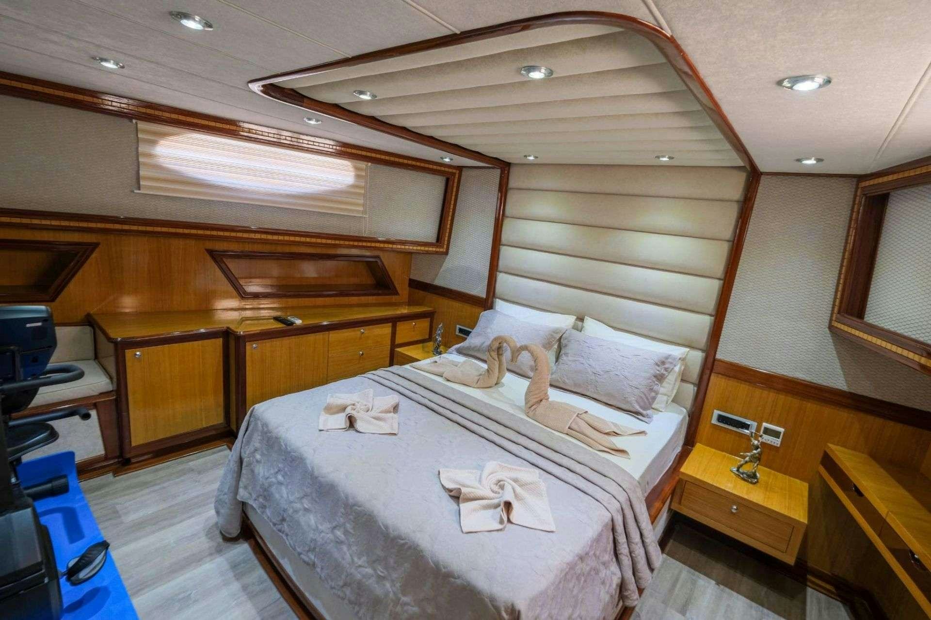 a bedroom with a bed and a desk aboard DESTINY Yacht for Charter