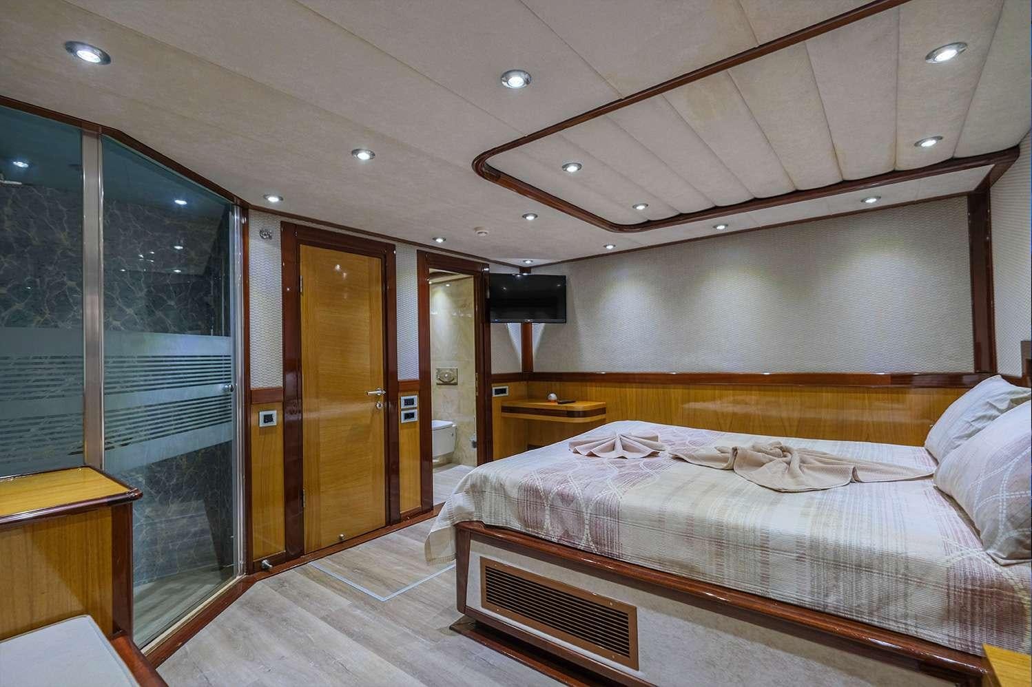 a bedroom with a bed and a desk aboard DESTINY Yacht for Charter