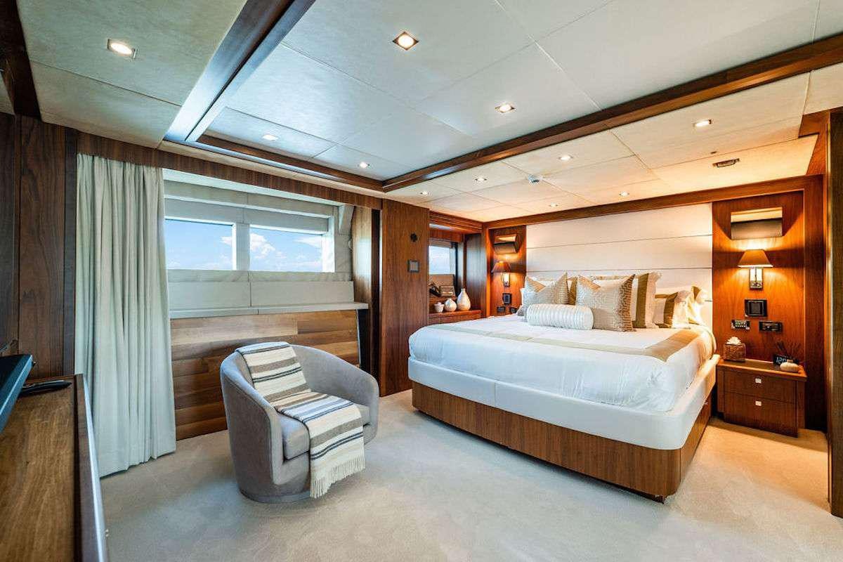 a bedroom with a bed and a chair aboard ABOUT TIME Yacht for Charter