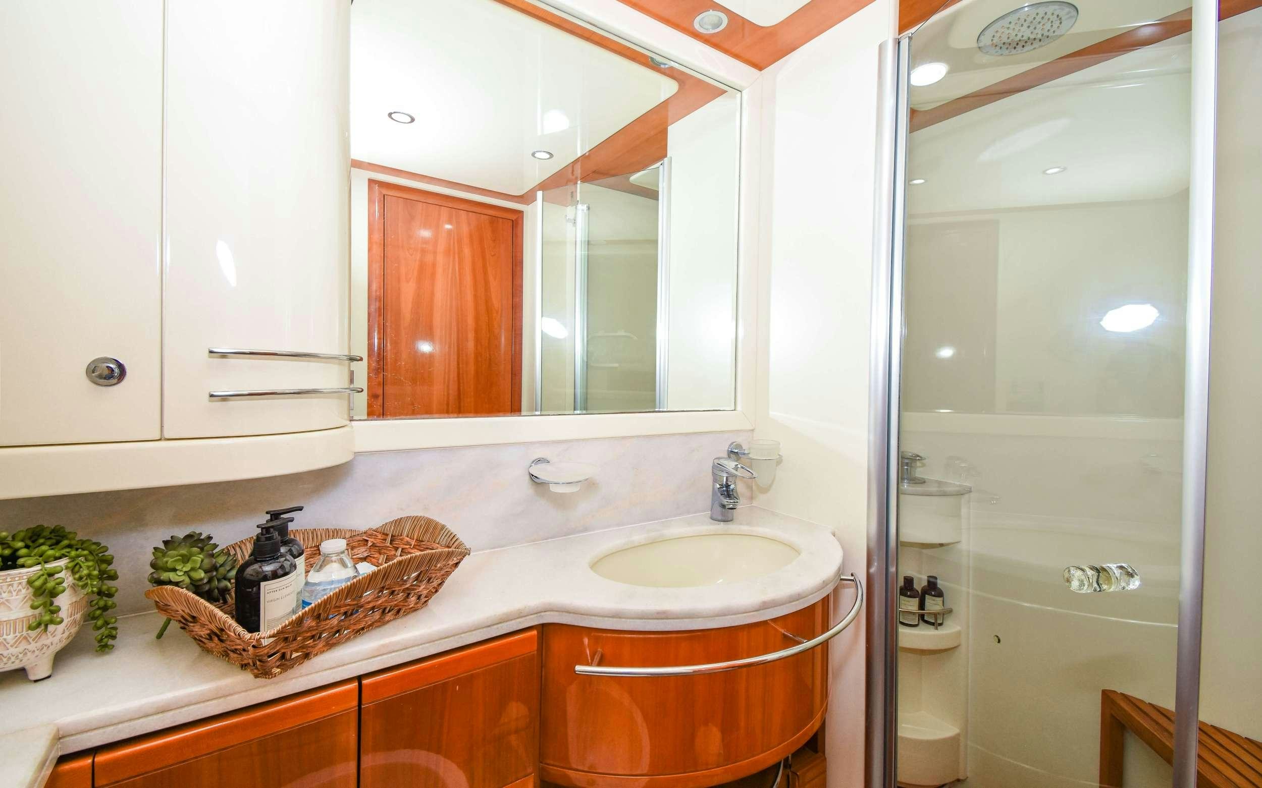 a bathroom with a sink and a mirror aboard INDULGE II Yacht for Charter