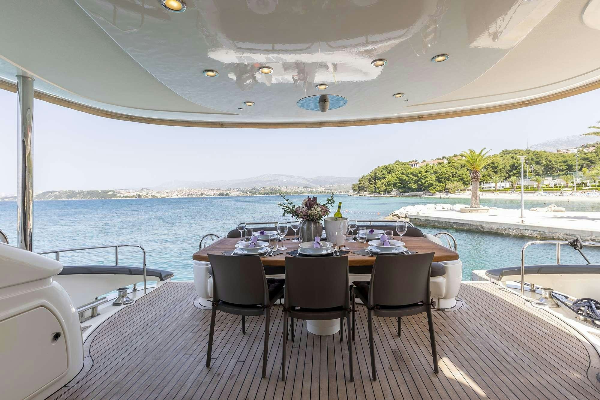 a table and chairs on a deck overlooking a body of water aboard SKYWATER Yacht for Charter