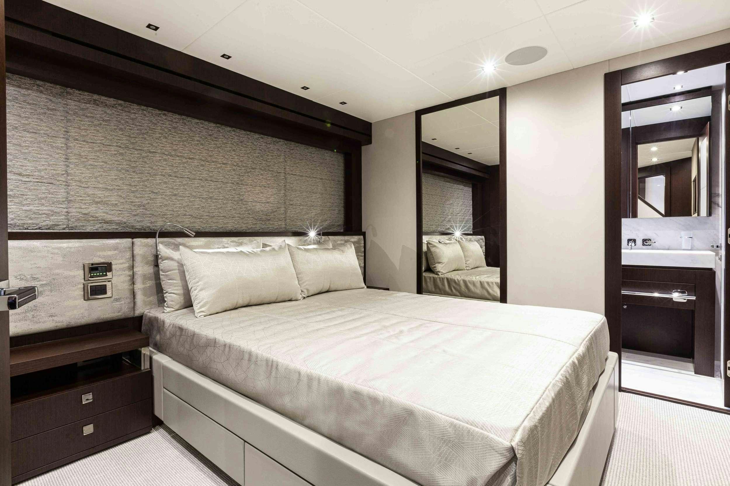 a bedroom with a bed and a mirror aboard NEW EDGE Yacht for Charter