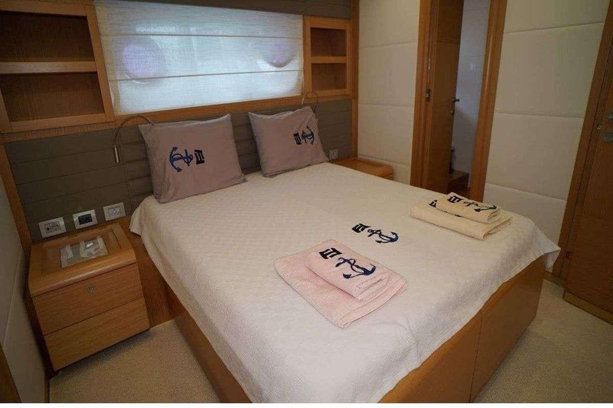 a bed with a white sheet and pillows on it aboard REINE DES COEURS Yacht for Charter