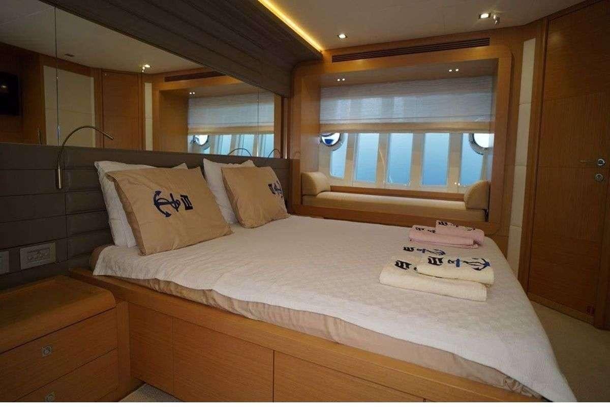 a bed with a white sheet aboard REINE DES COEURS Yacht for Charter