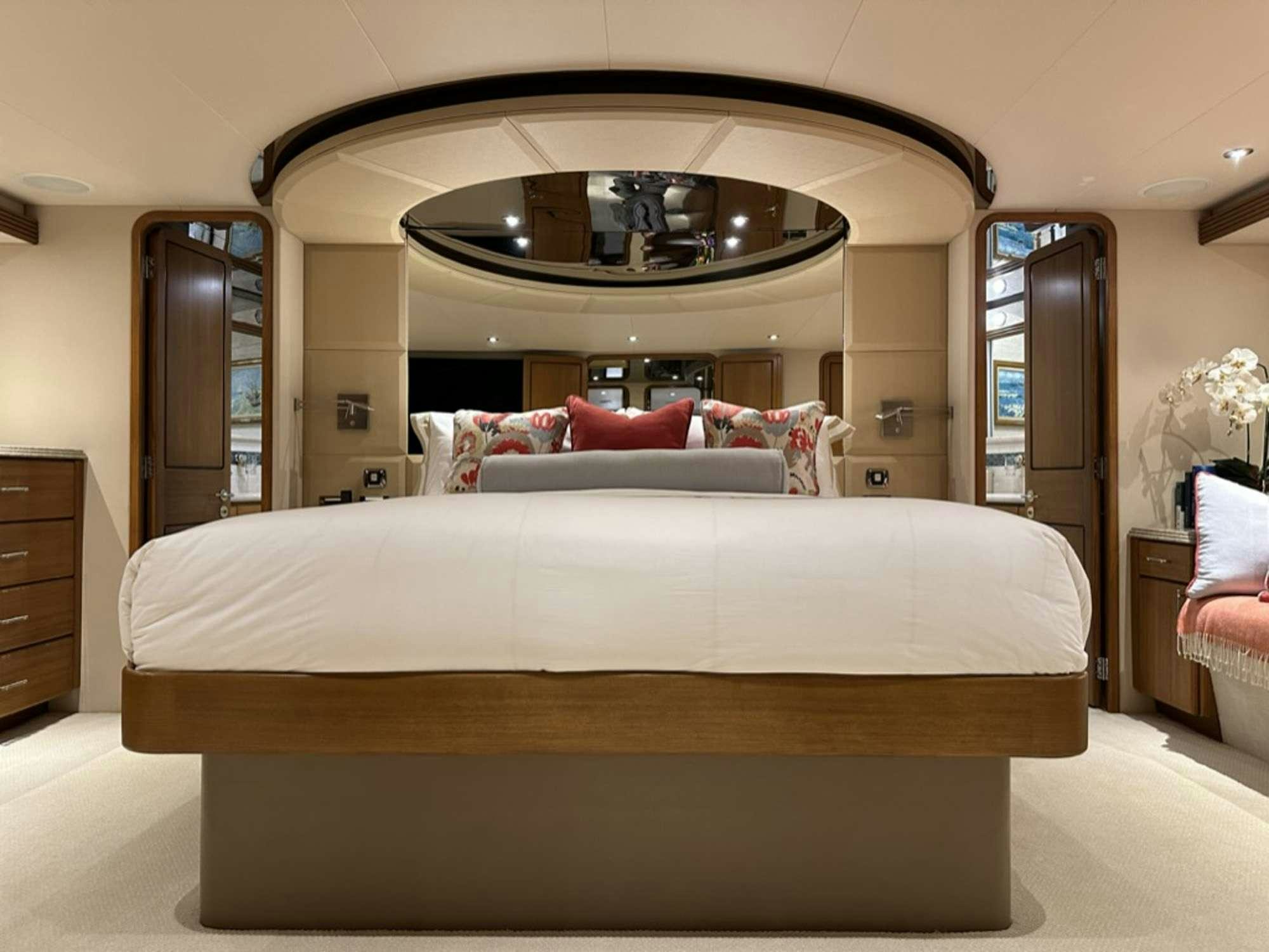 a bed with a white bed spread aboard ISLAND GIRL Yacht for Charter