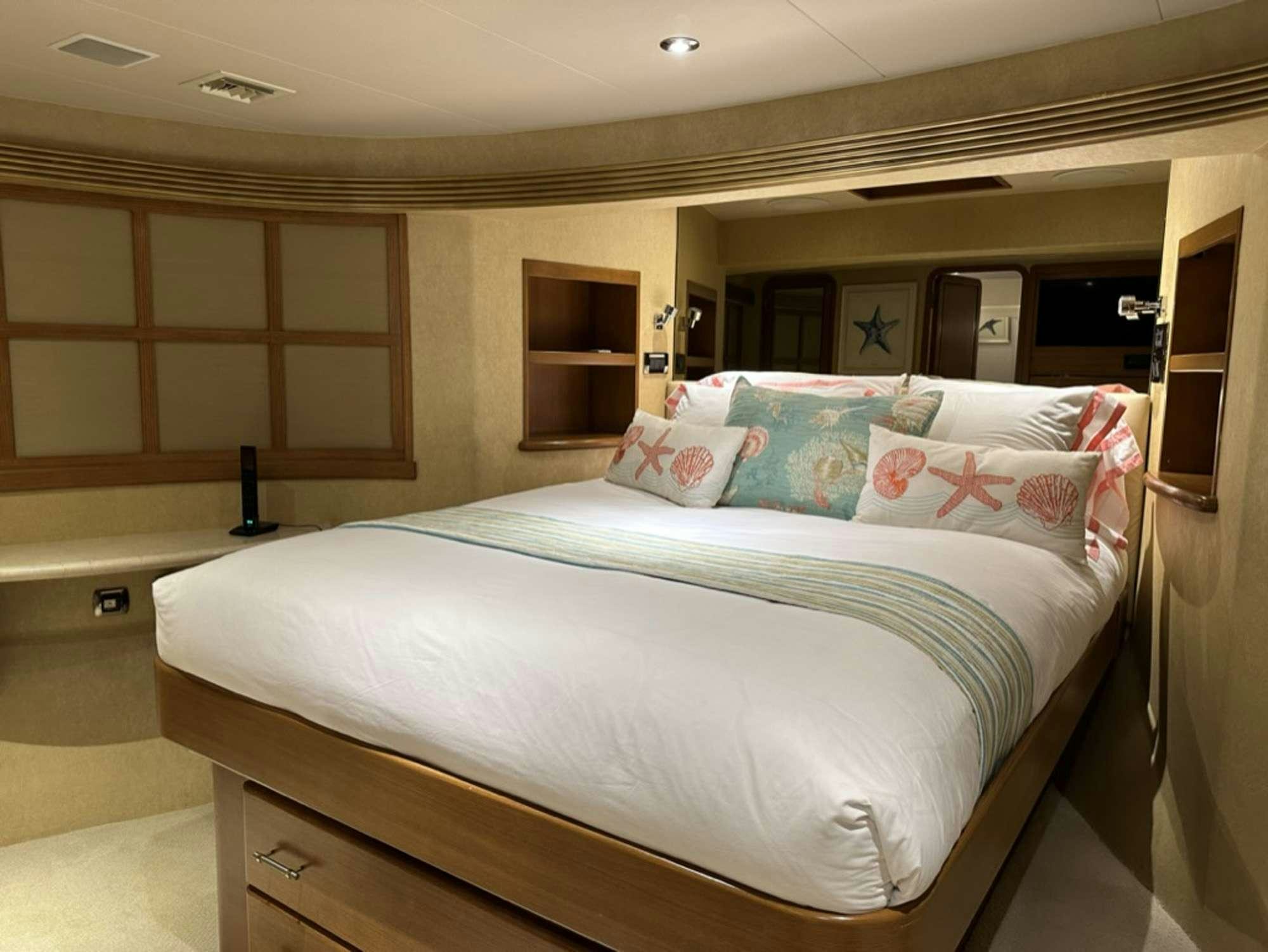 a bed with a blue and pink comforter aboard ISLAND GIRL Yacht for Charter