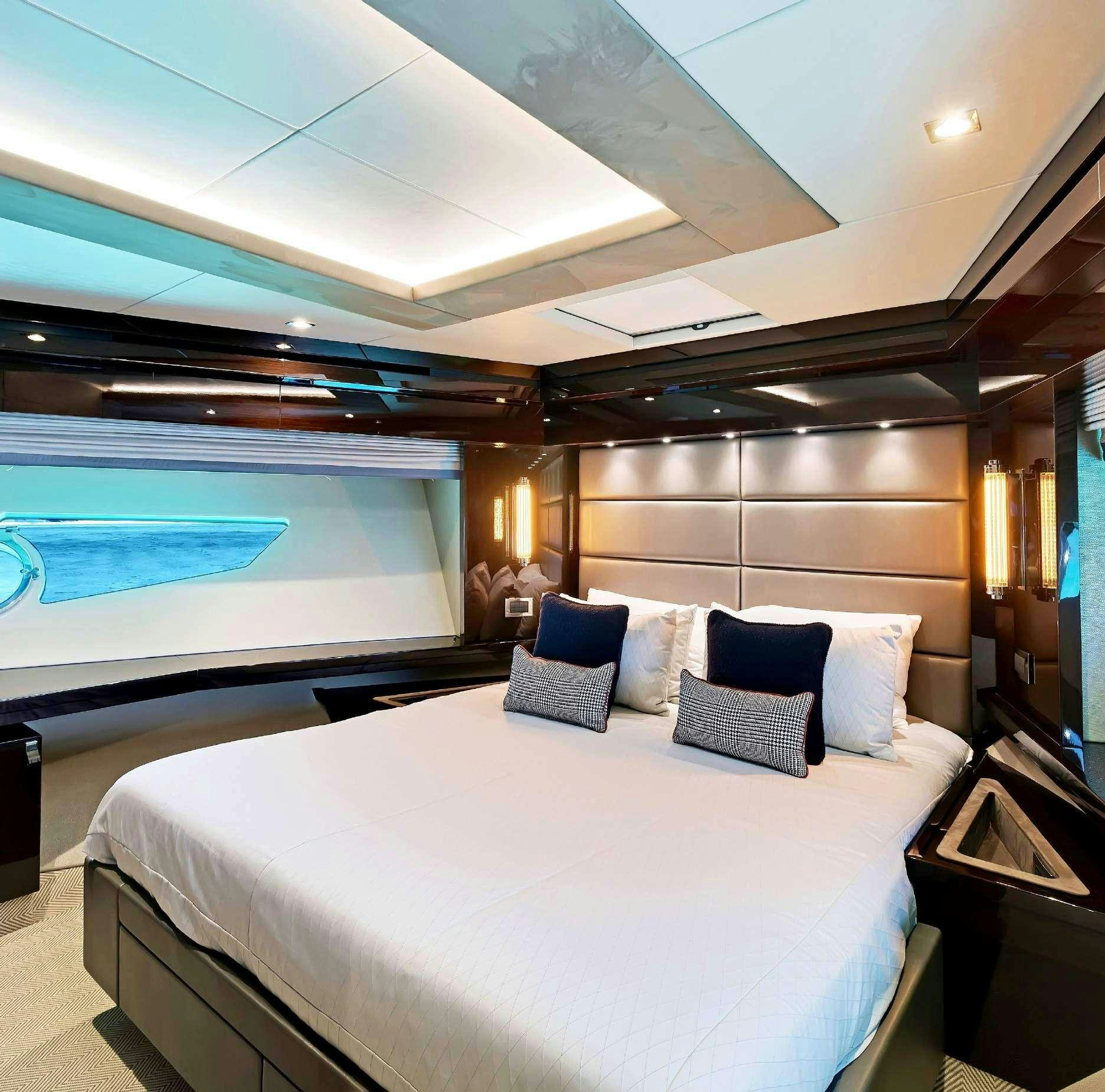 a room with a bed and a large window aboard SYNERGY Yacht for Charter