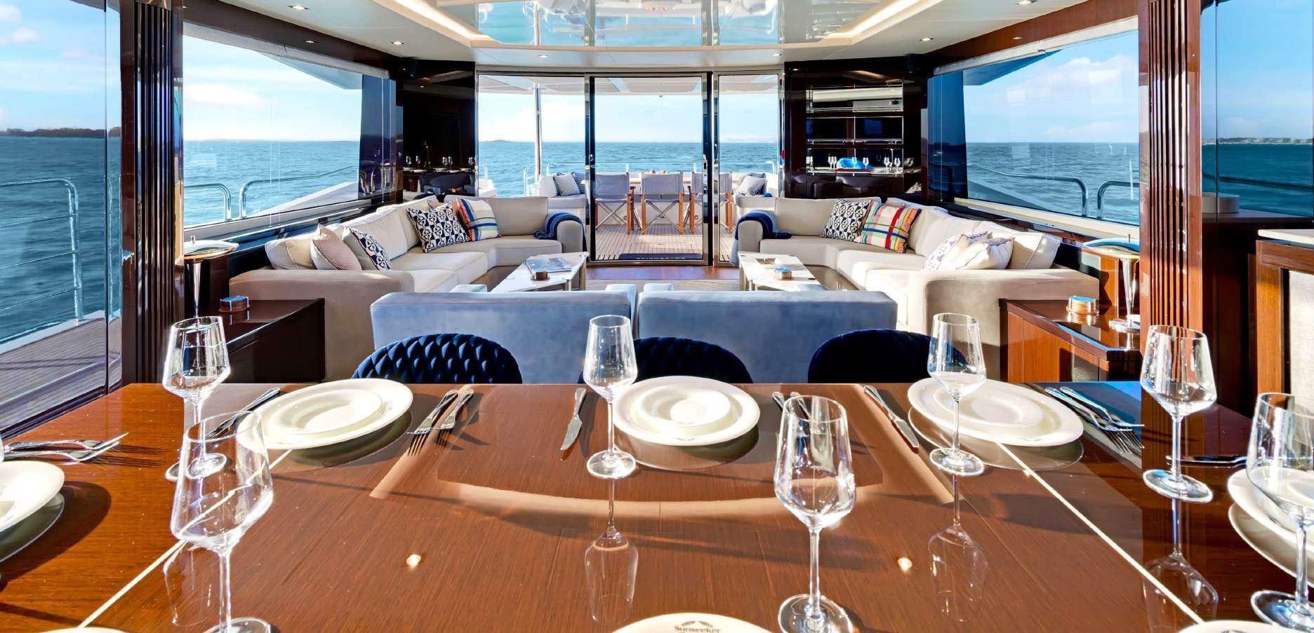 a dining room table with empty wine glasses and plates aboard SYNERGY Yacht for Charter