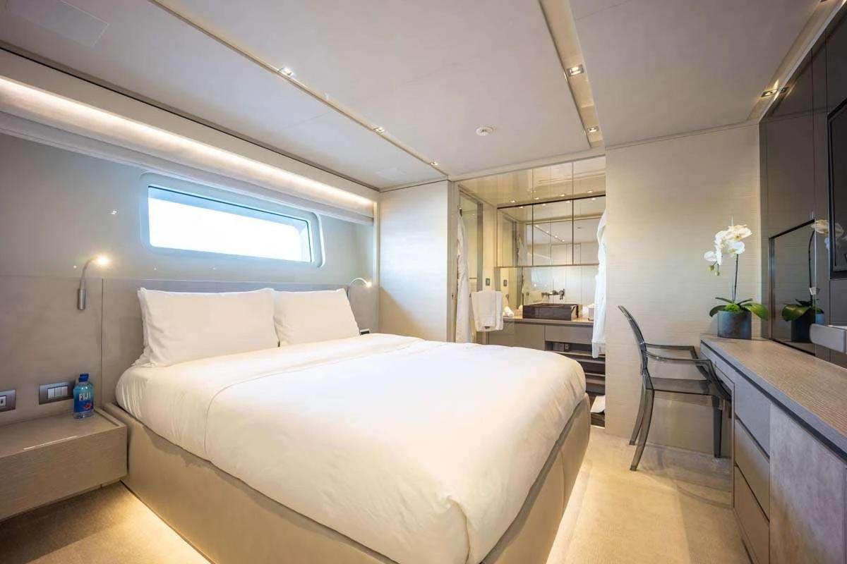 a bedroom with a bed and a chair aboard PHOENIX Yacht for Charter