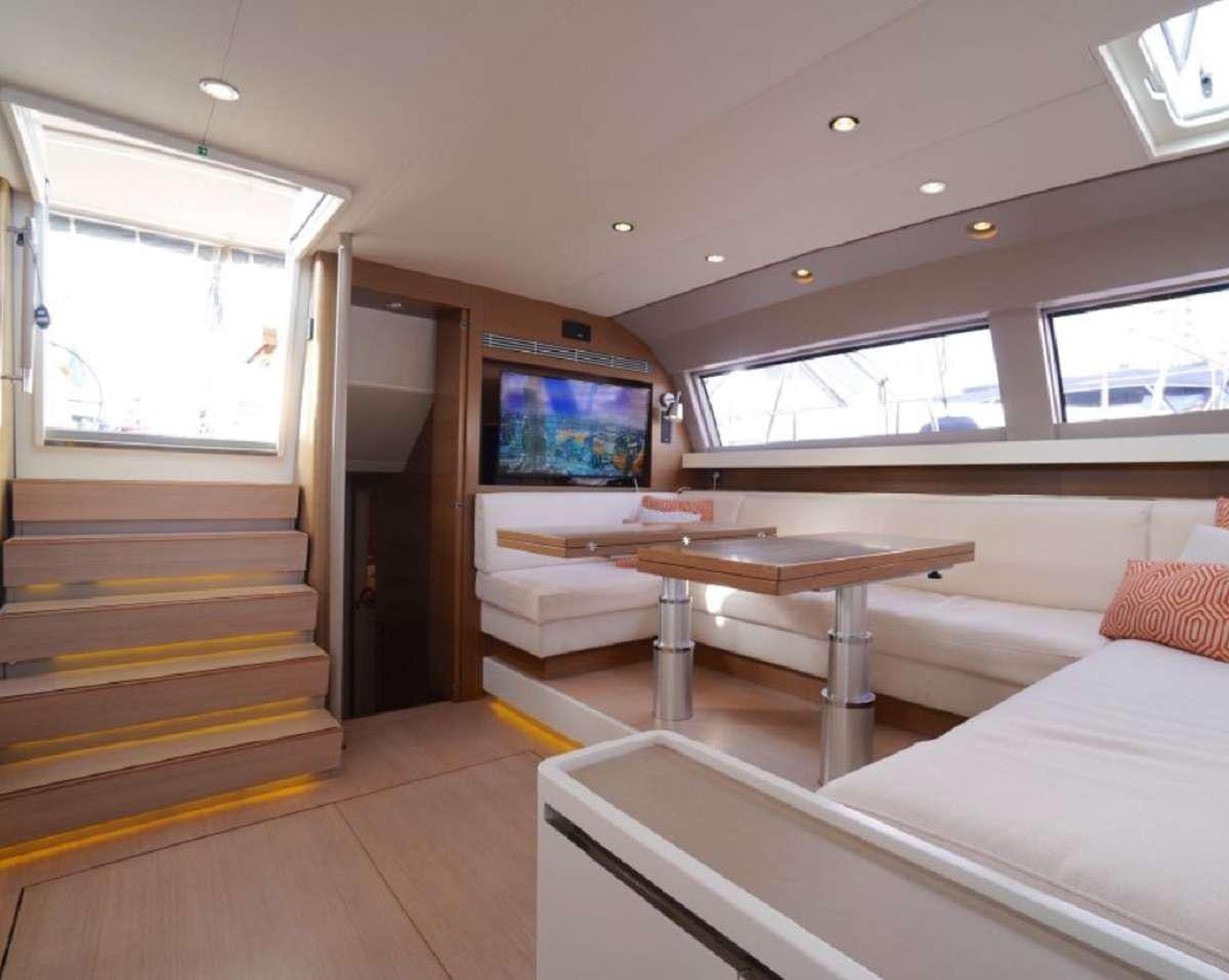a room with a table and couch aboard AENEA Yacht for Charter