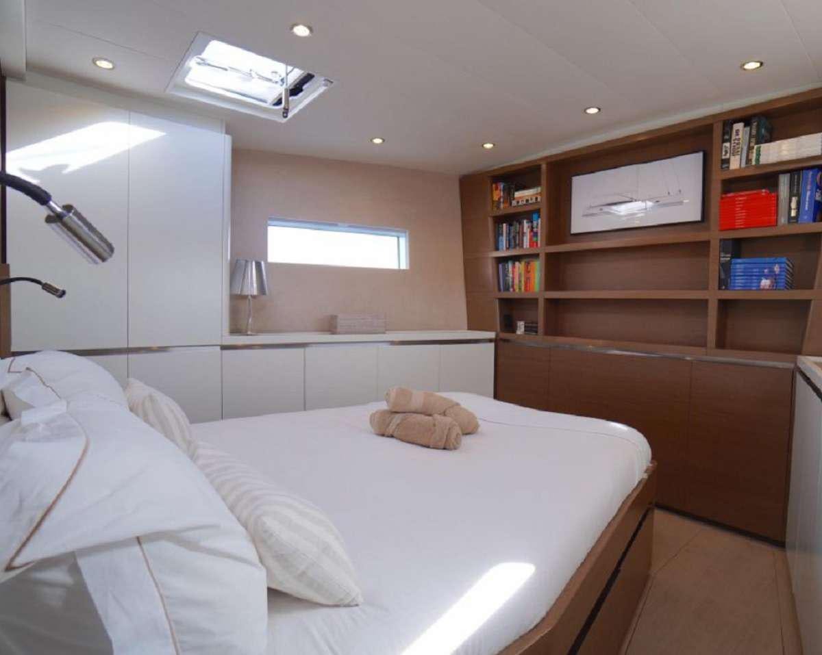 a bedroom with a bed and a shelf aboard AENEA Yacht for Charter