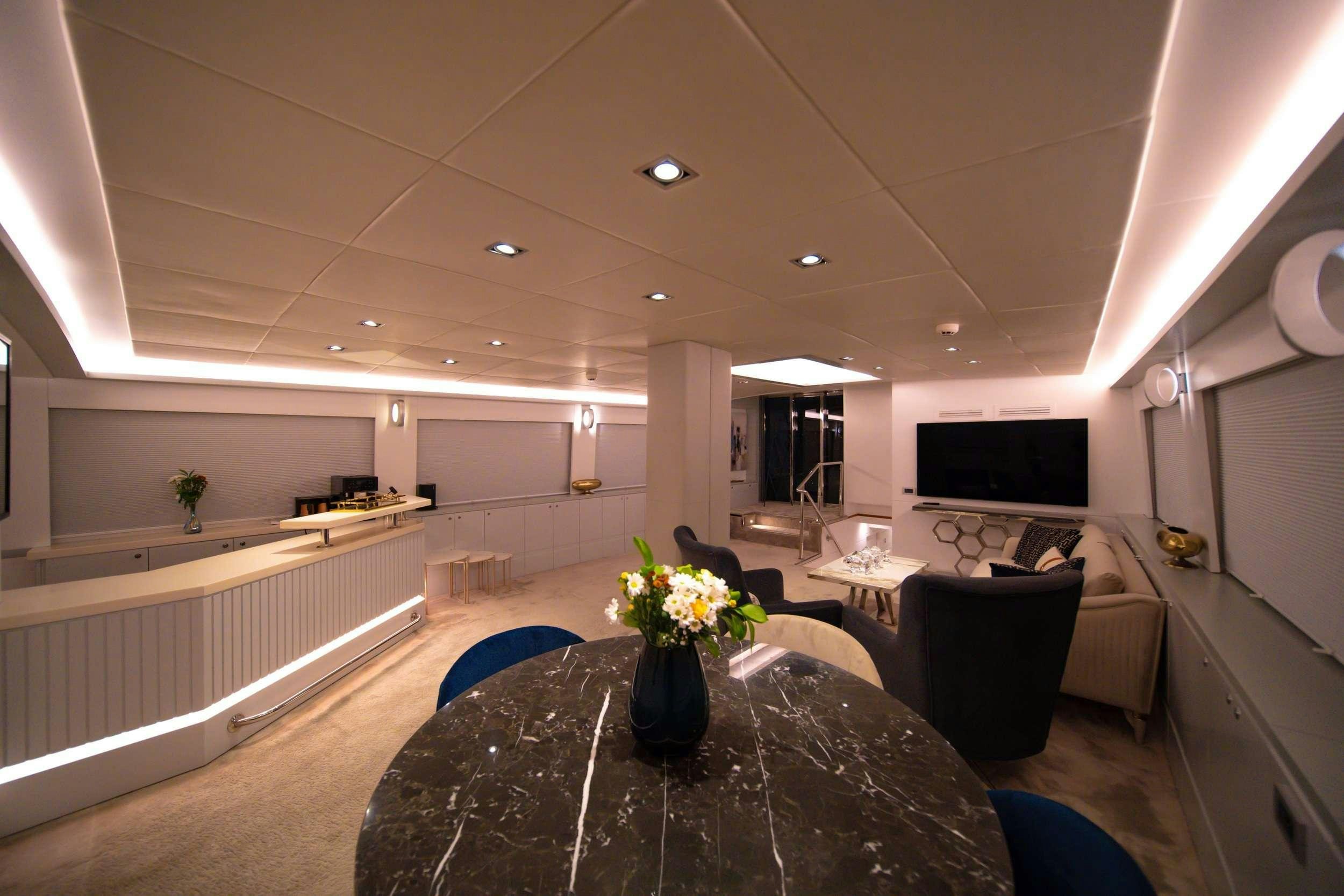 a large living room with a black table and black chairs aboard DOUBLE EAGLE Yacht for Charter