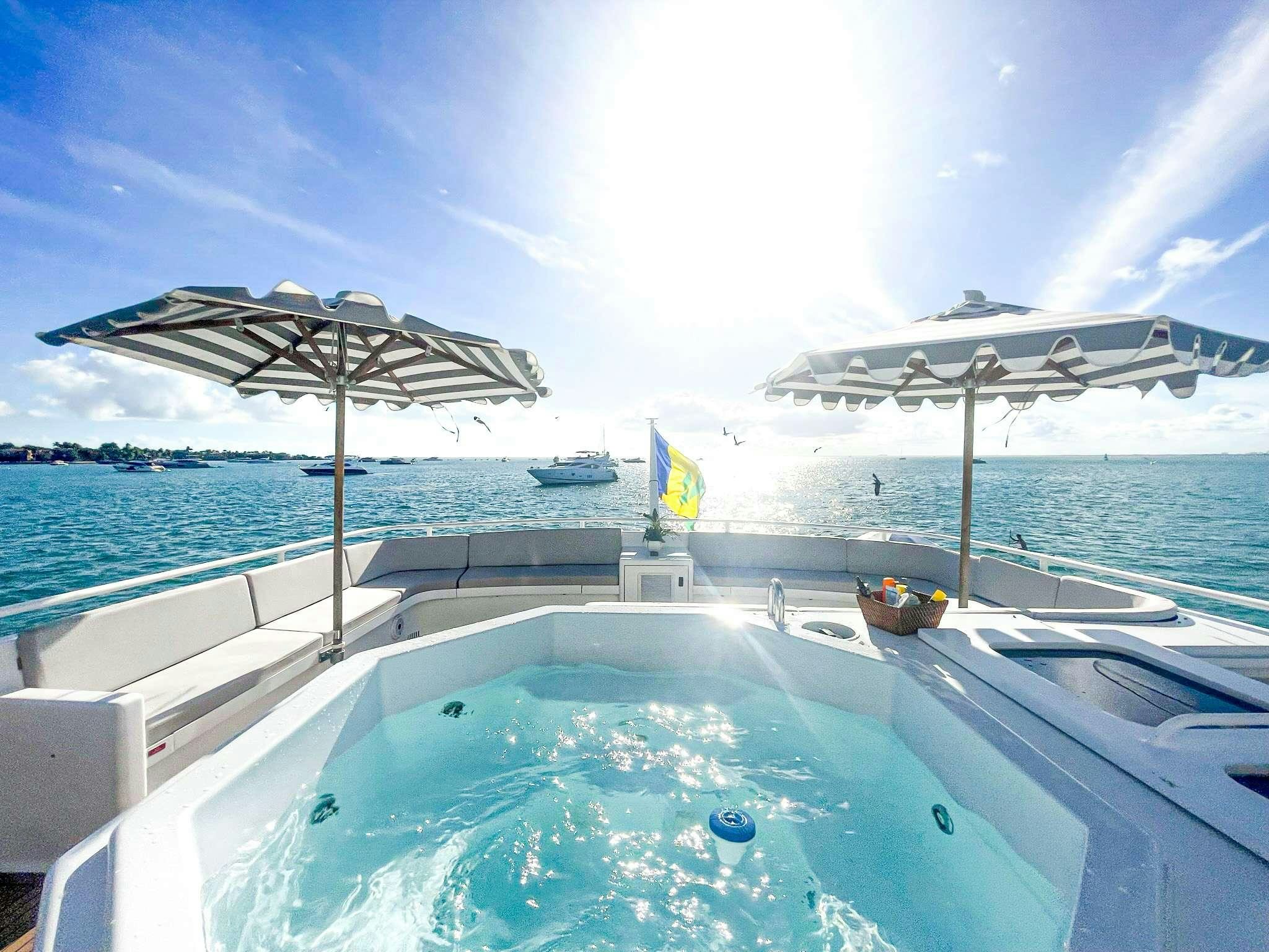 a pool with umbrellas and a cabana on it aboard ROGUE Yacht for Charter