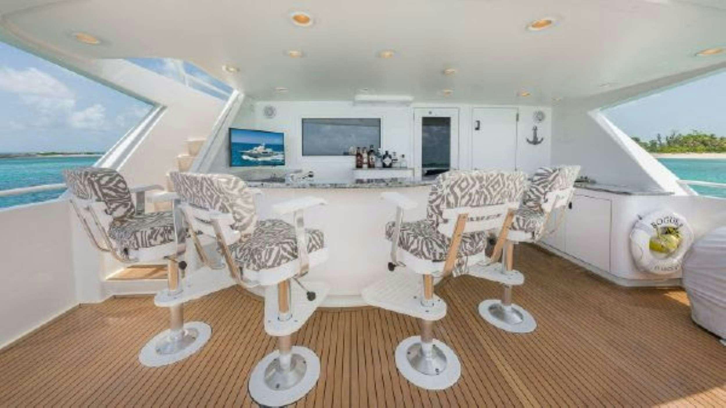 a room with a table chairs and a television aboard ROGUE Yacht for Charter