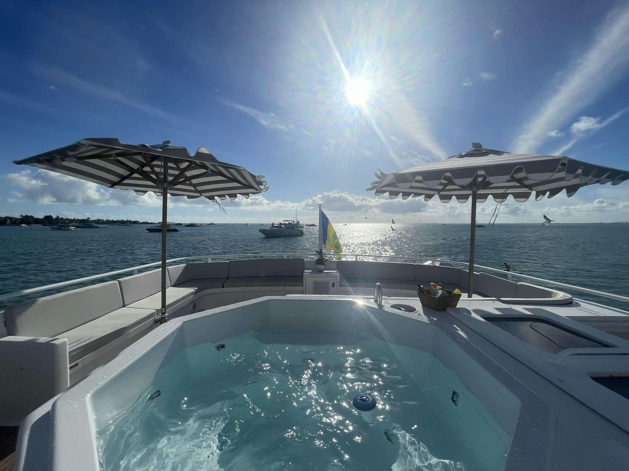 a pool with umbrellas and a cabana on it aboard ROGUE Yacht for Charter