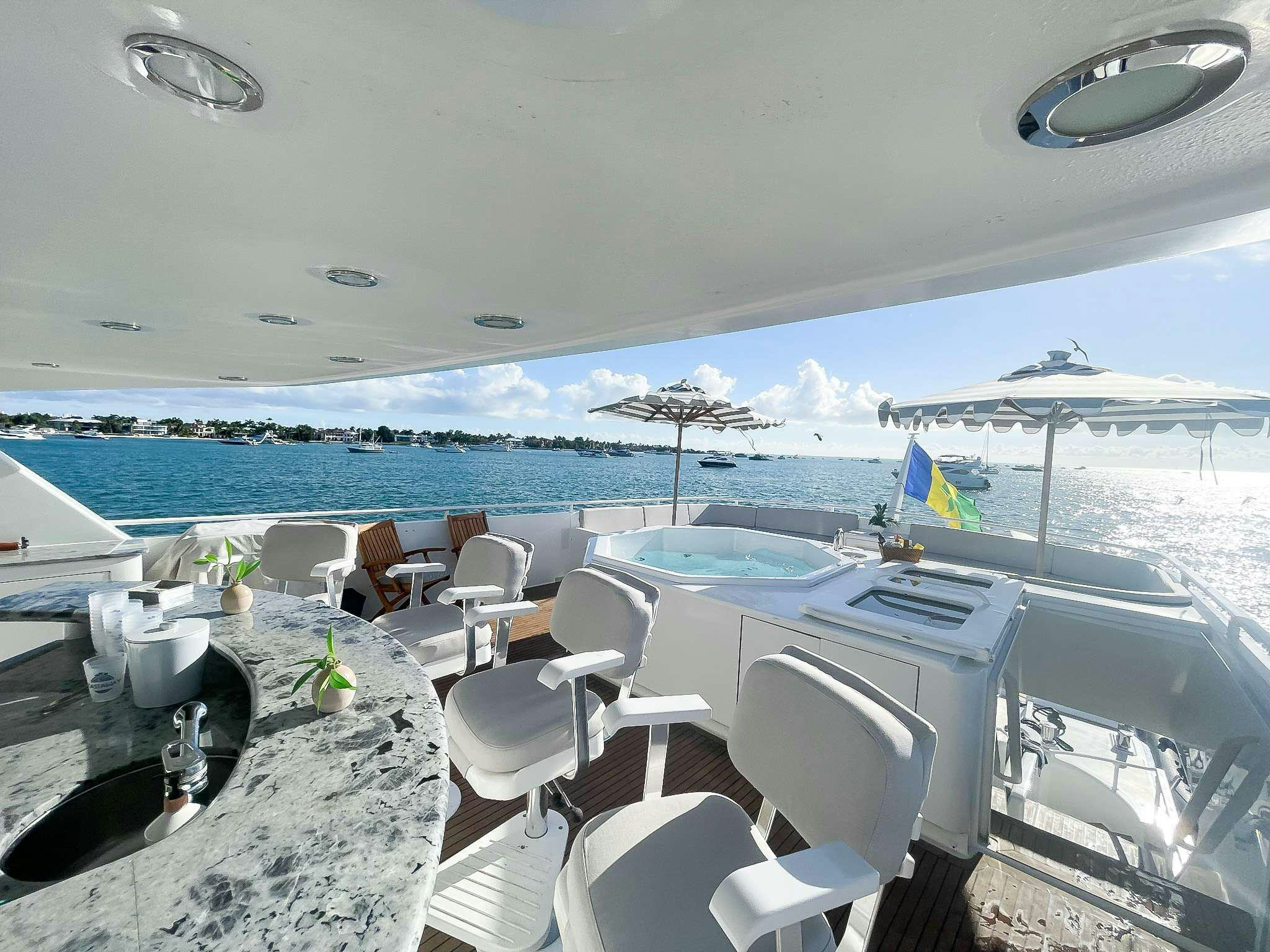 a room with a table chairs and umbrellas aboard ROGUE Yacht for Charter