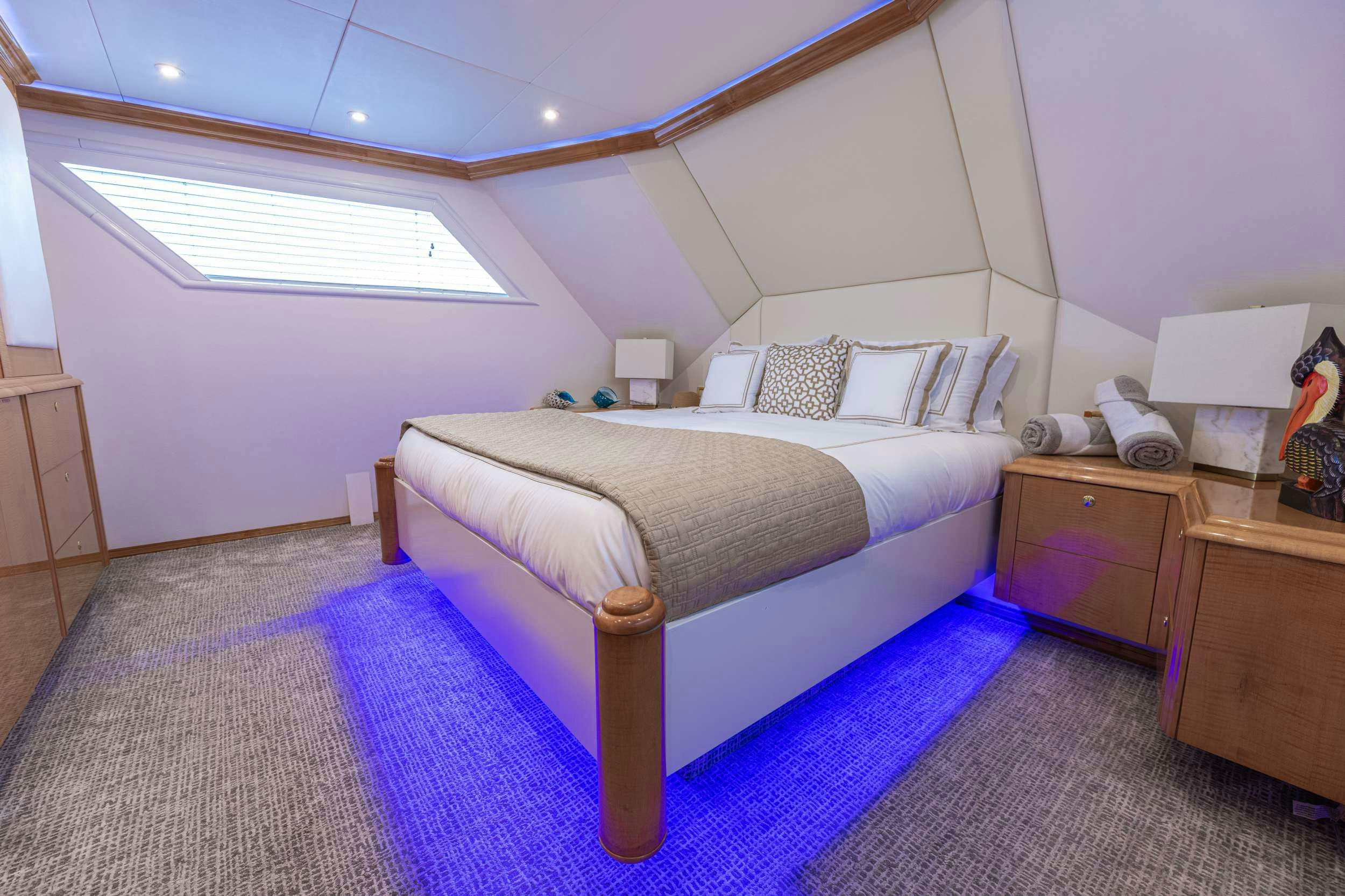 a bedroom with a bed and a desk aboard ROGUE Yacht for Charter