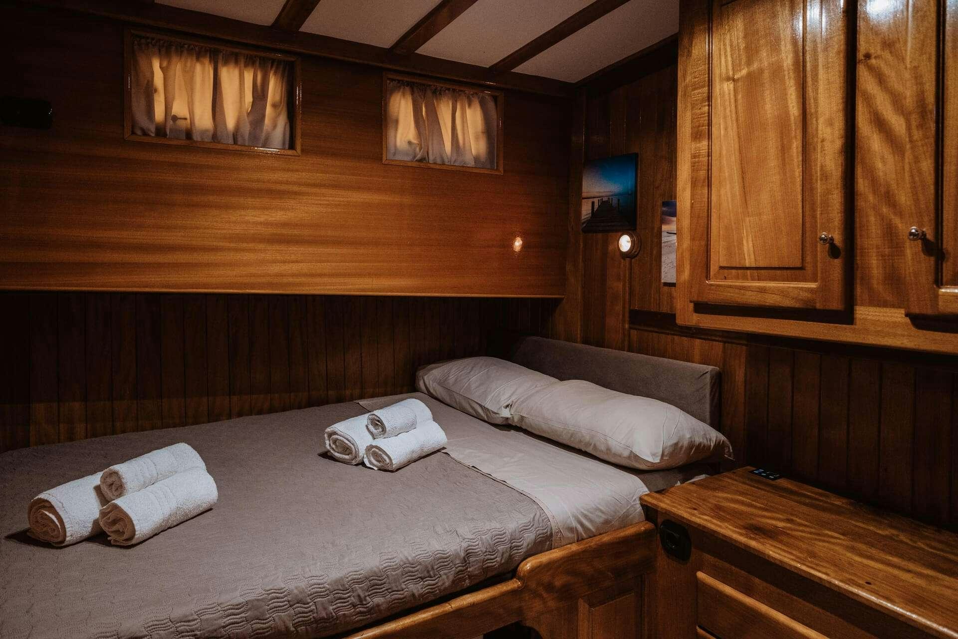 a room with a bed and a television aboard HANDE CAPO GALERA Yacht for Charter