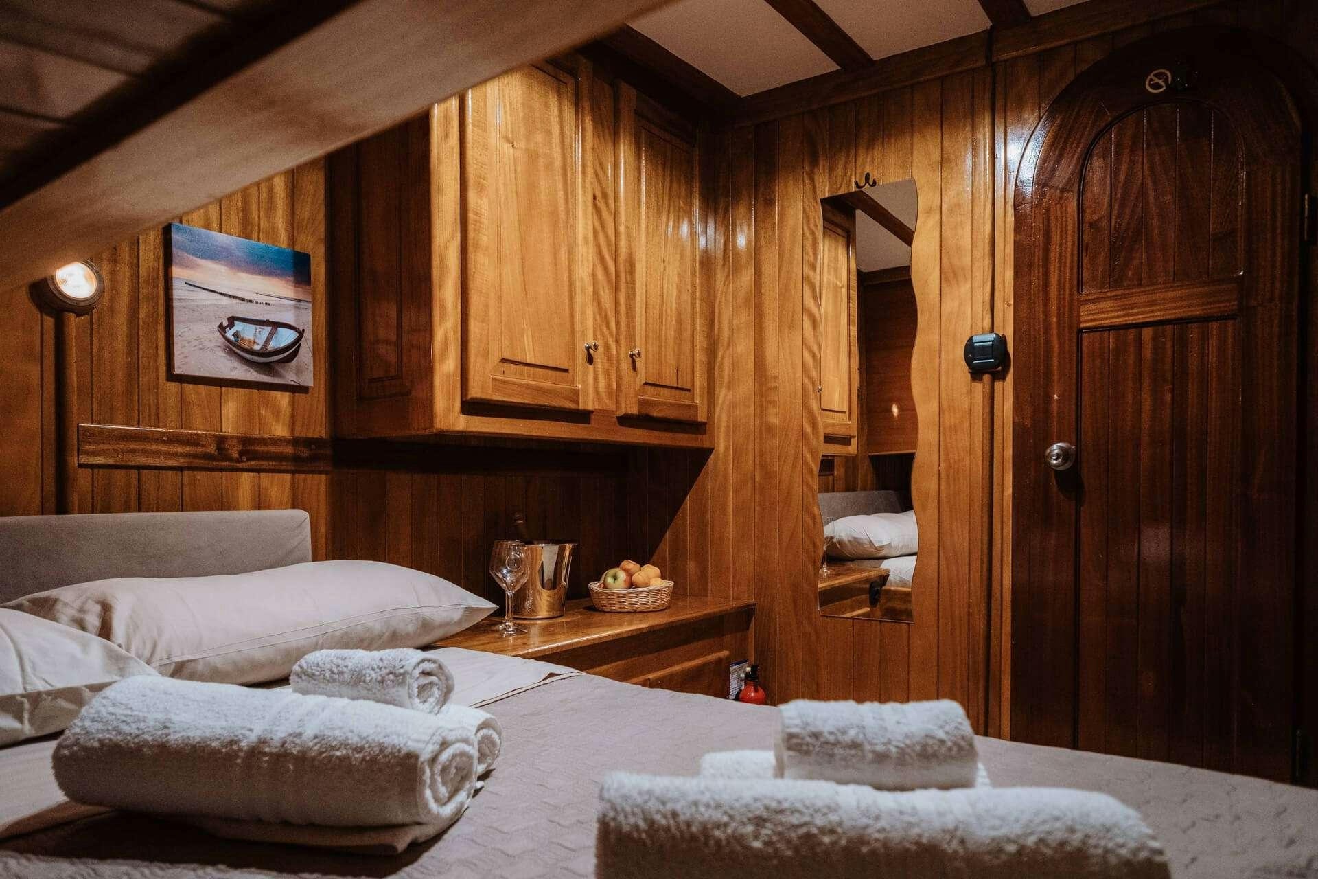 a room with a bed and a mirror aboard HANDE CAPO GALERA Yacht for Charter
