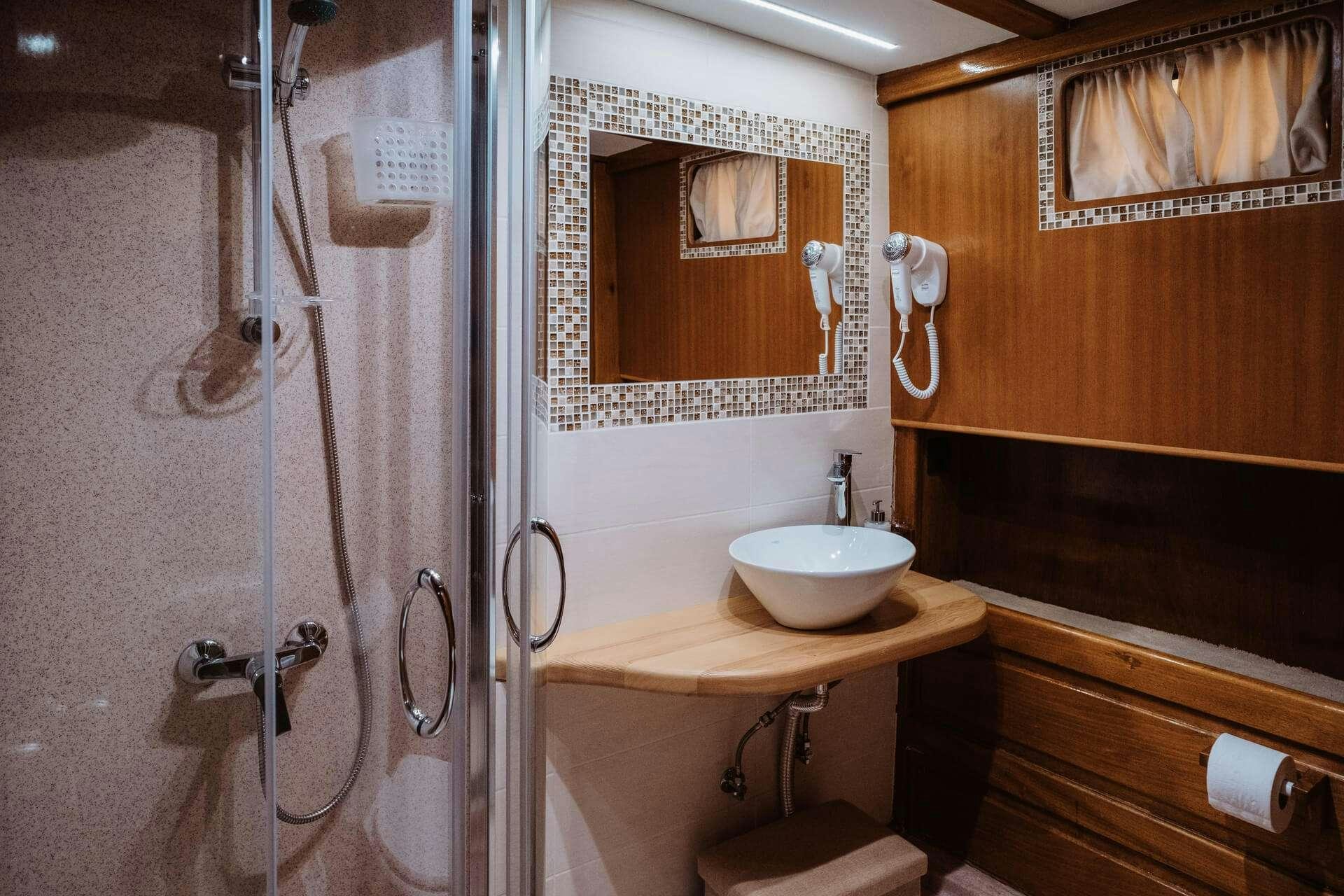 a bathroom with a sink and a shower aboard HANDE CAPO GALERA Yacht for Charter