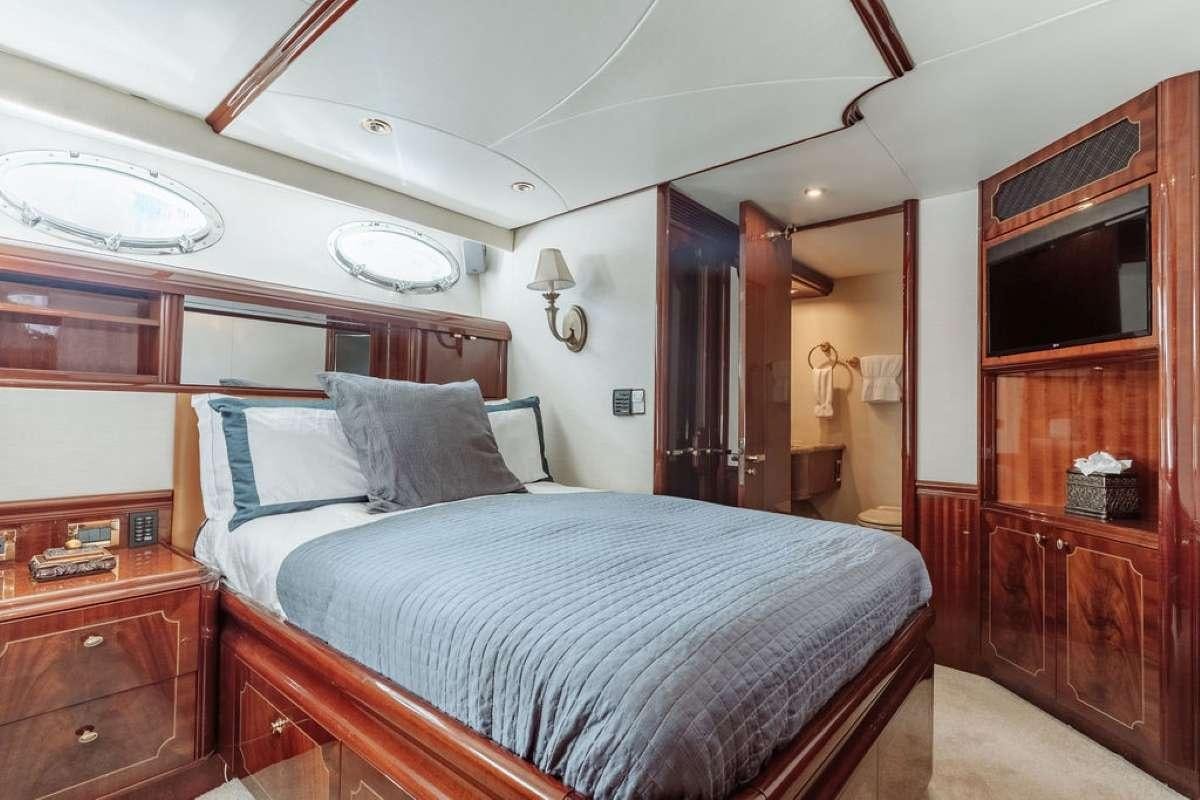 a bedroom with a bed and a wood cabinet aboard LADY KRISTINA Yacht for Charter