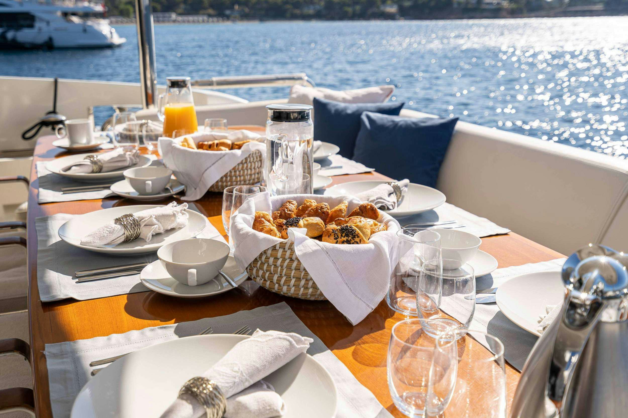 a table with food and drinks on it aboard KOUKLES Yacht for Charter