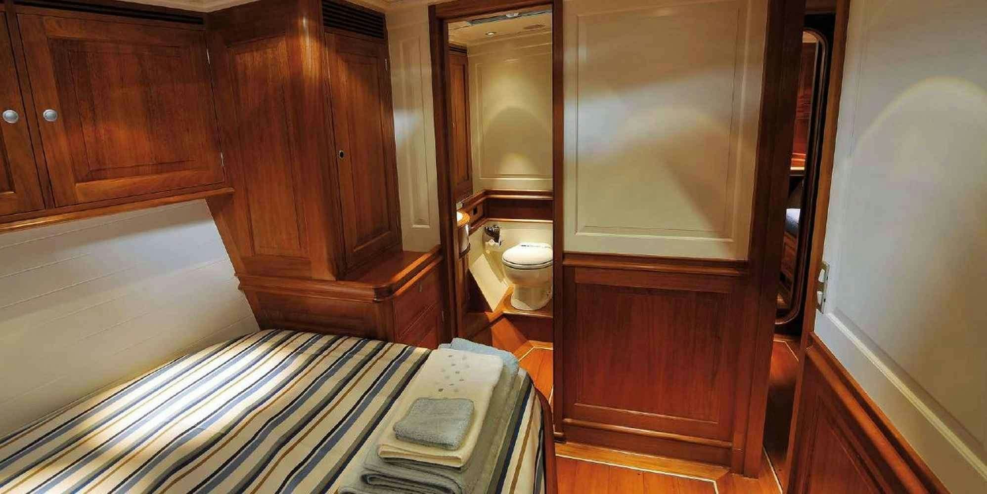 a bathroom with a toilet and a wooden cabinet aboard ATALANTE Yacht for Charter