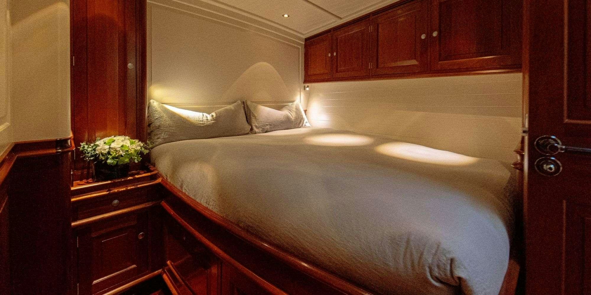 a bed with white sheets aboard ATALANTE Yacht for Charter