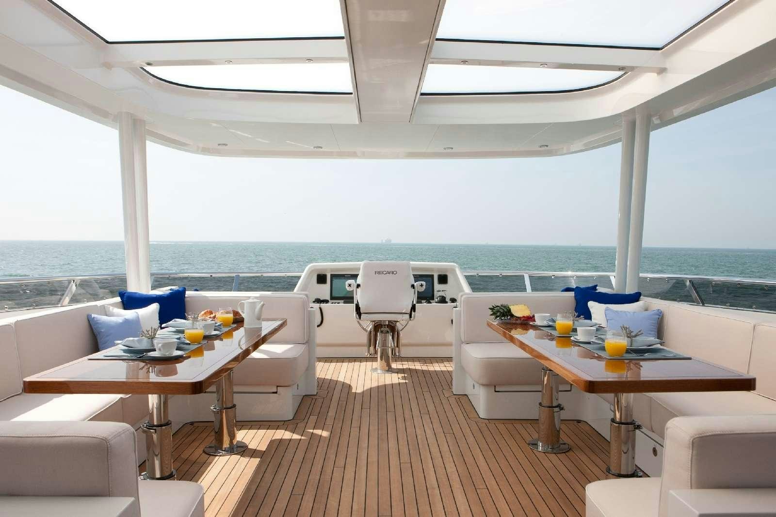 a room with a table chairs and a large window aboard FIREFLY Yacht for Charter