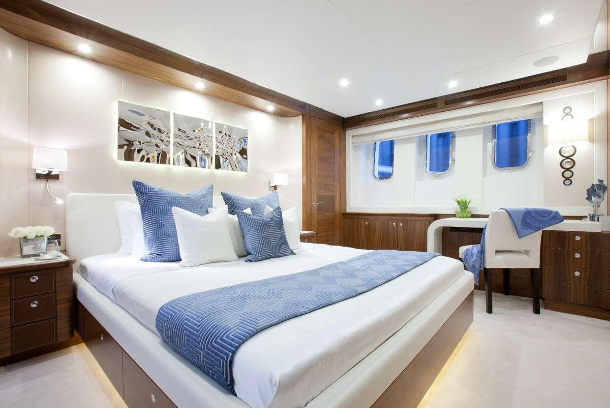 a bedroom with a bed and desk aboard FIREFLY Yacht for Charter