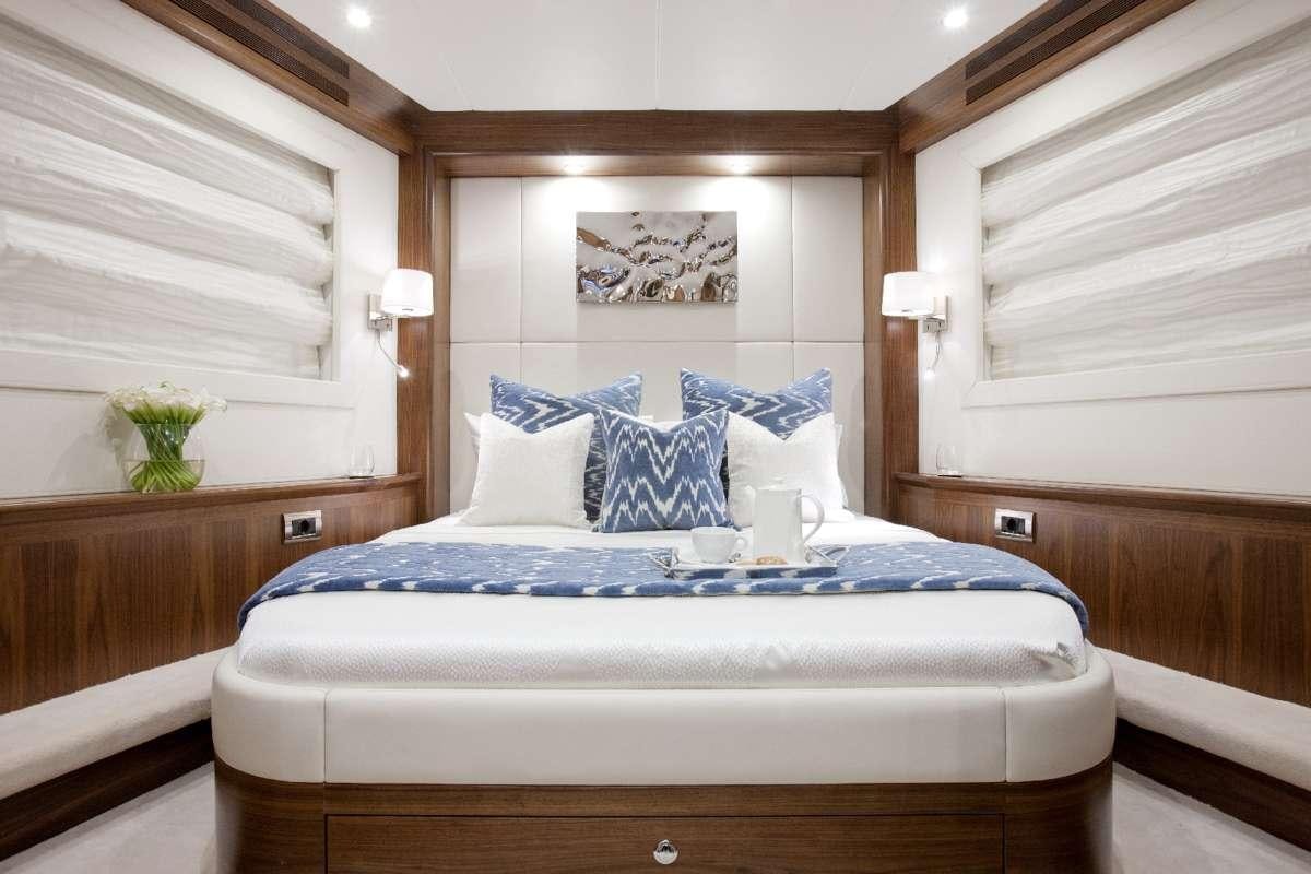 a bed with blue sheets aboard FIREFLY Yacht for Charter