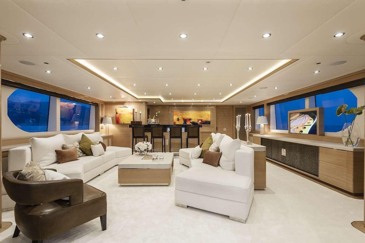 a room with a couch and a tv on the wall aboard AUDACES Yacht for Charter