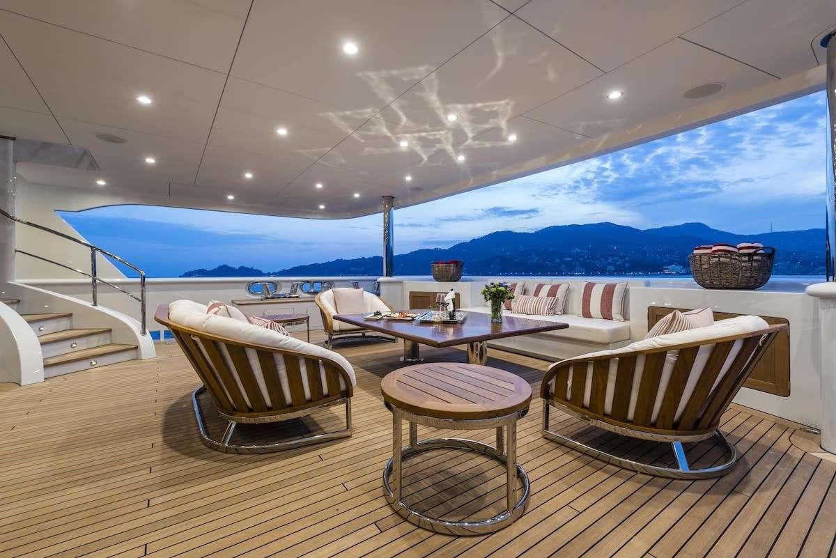 a room with a table chairs and a large body of water aboard AUDACES Yacht for Charter