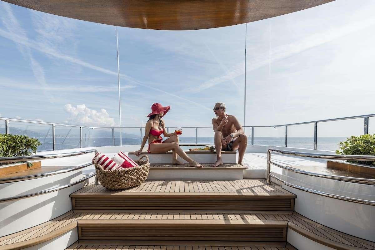 a man and a woman sitting on a dock aboard AUDACES Yacht for Charter