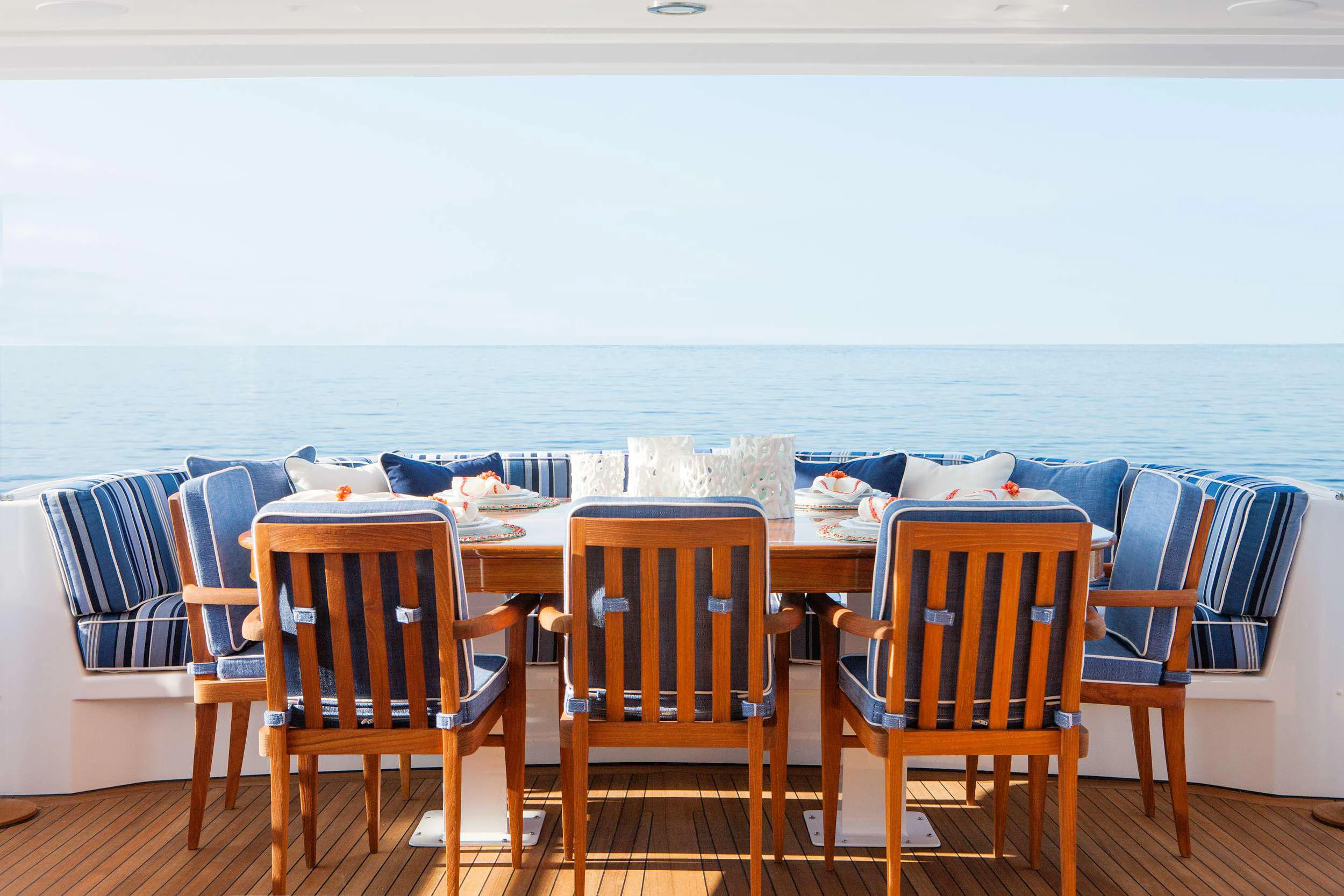 a table with chairs and a large body of water in the background aboard HANNAH Yacht for Charter