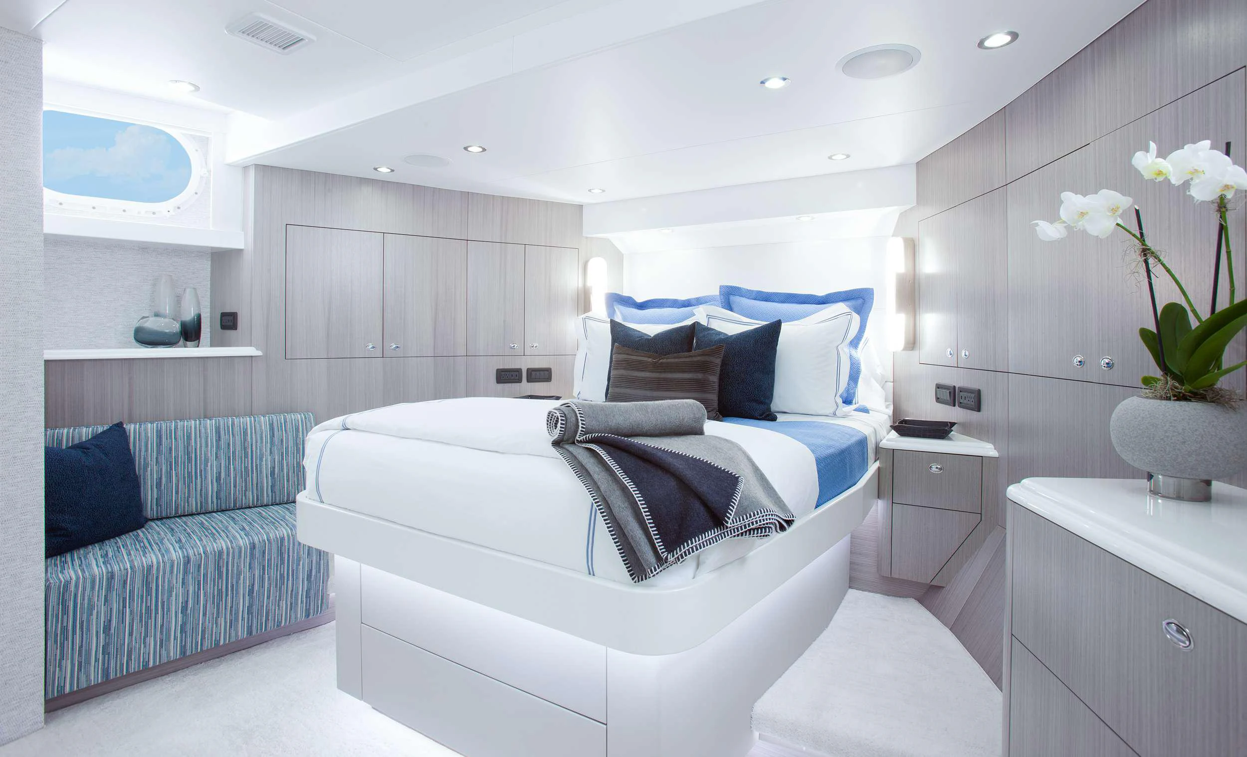 a white bedroom with a blue bed aboard HANNAH Yacht for Charter