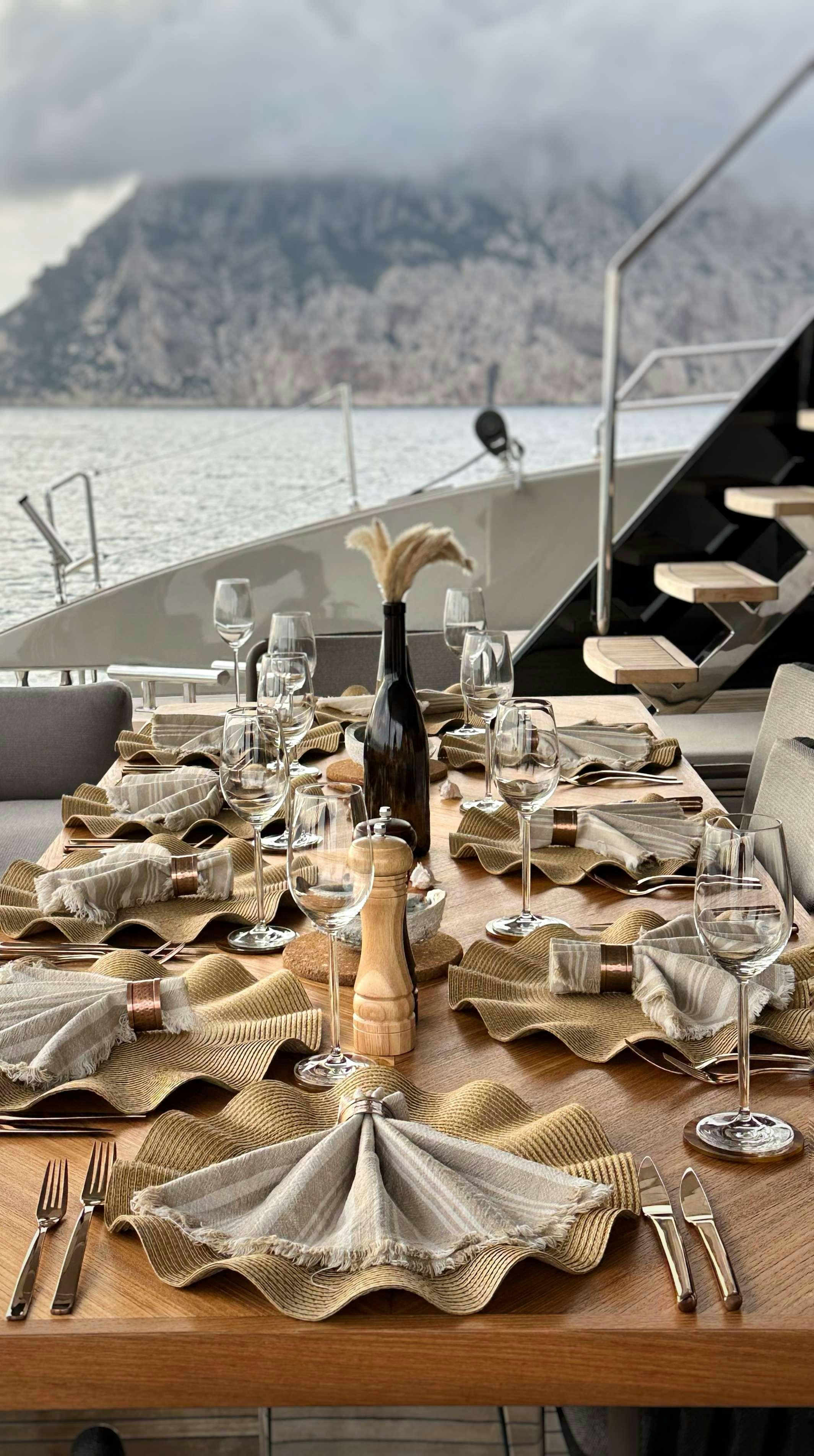 a table with wine glasses and napkins on it aboard VIVA LA VIDA Yacht for Charter